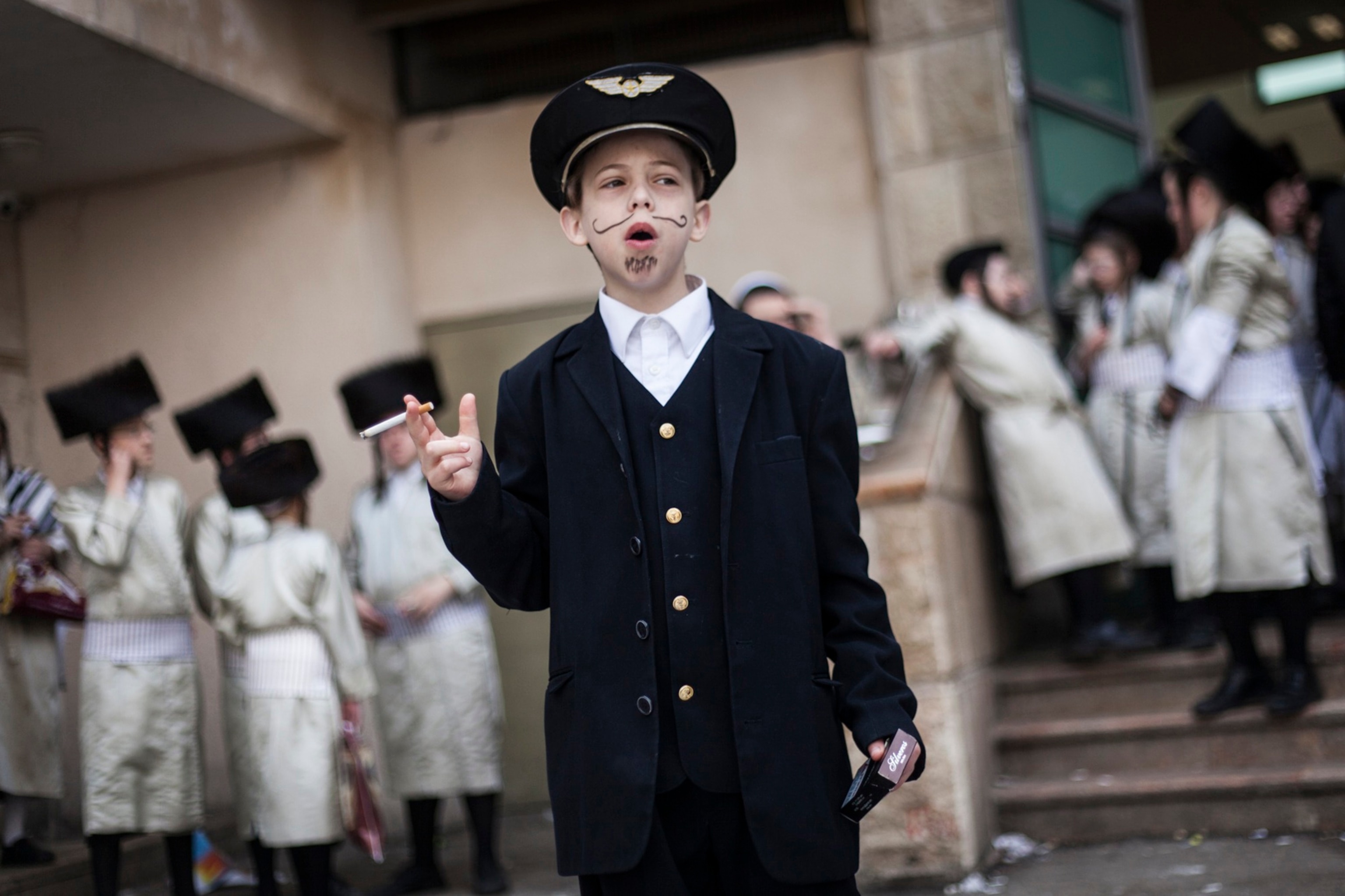 a young boy sitting on the street reading