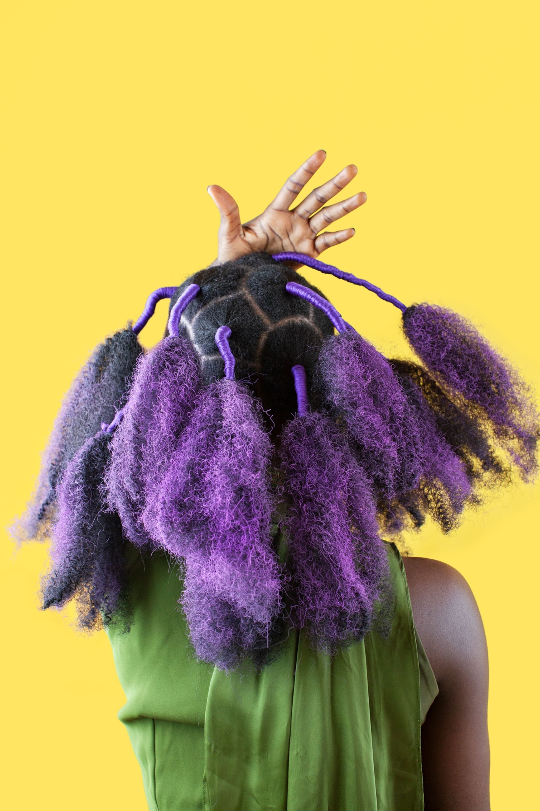 Picture of woman with purple wool plumages added to her hairdo.