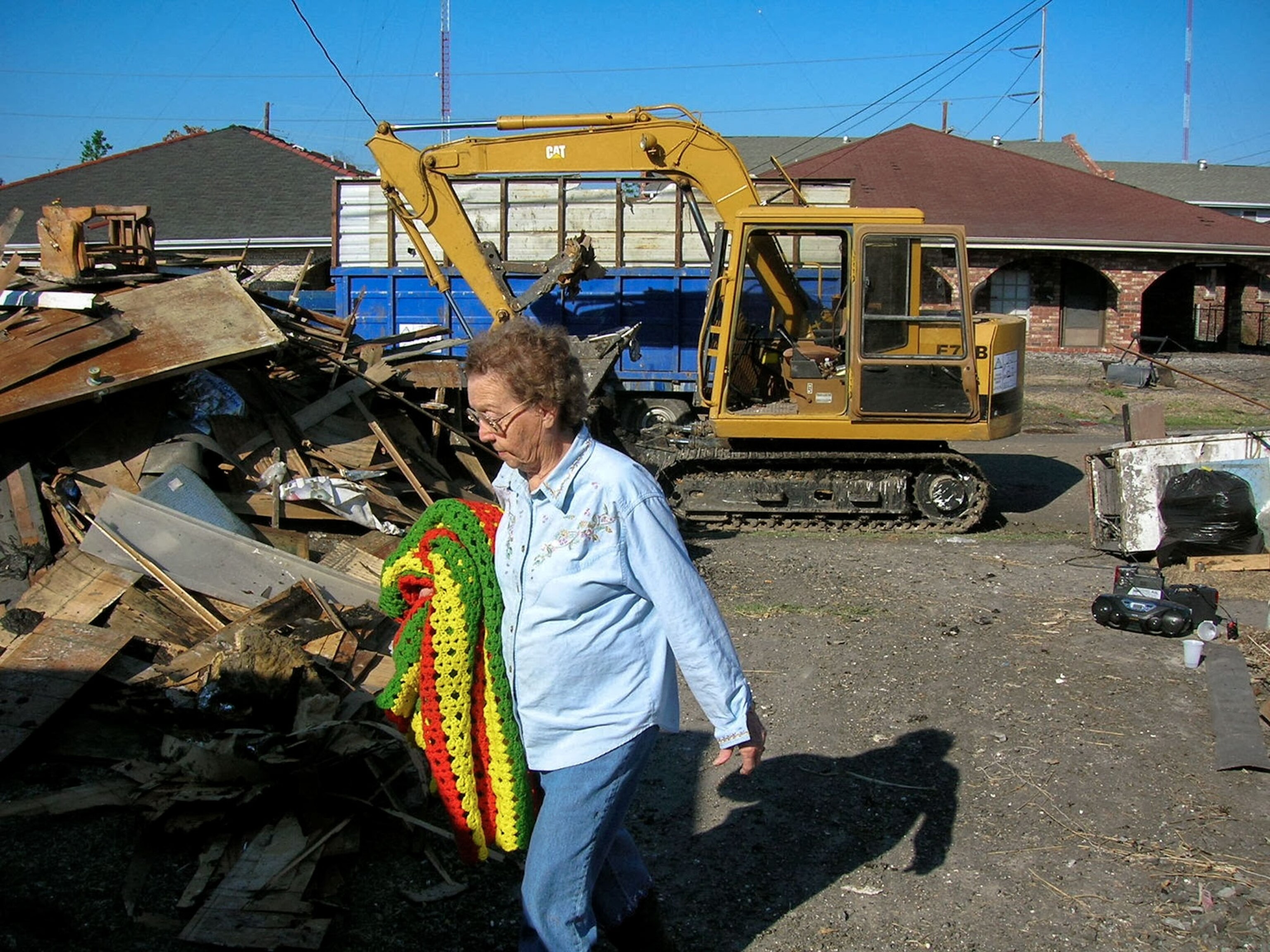 a woman cleaning up rubble around her house after Hurricane Katrina