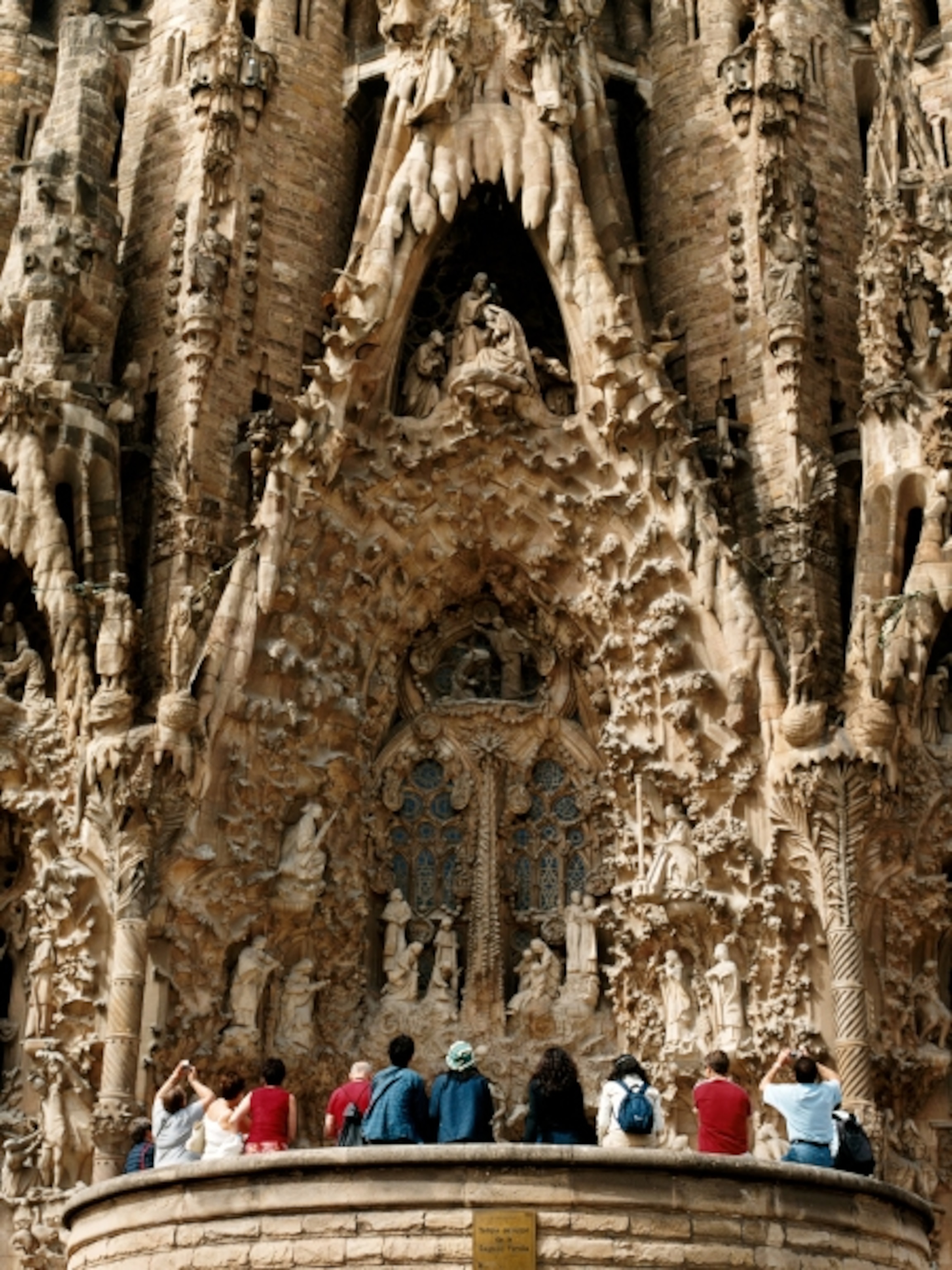 Tourists staring at elaborately decorated façade of church