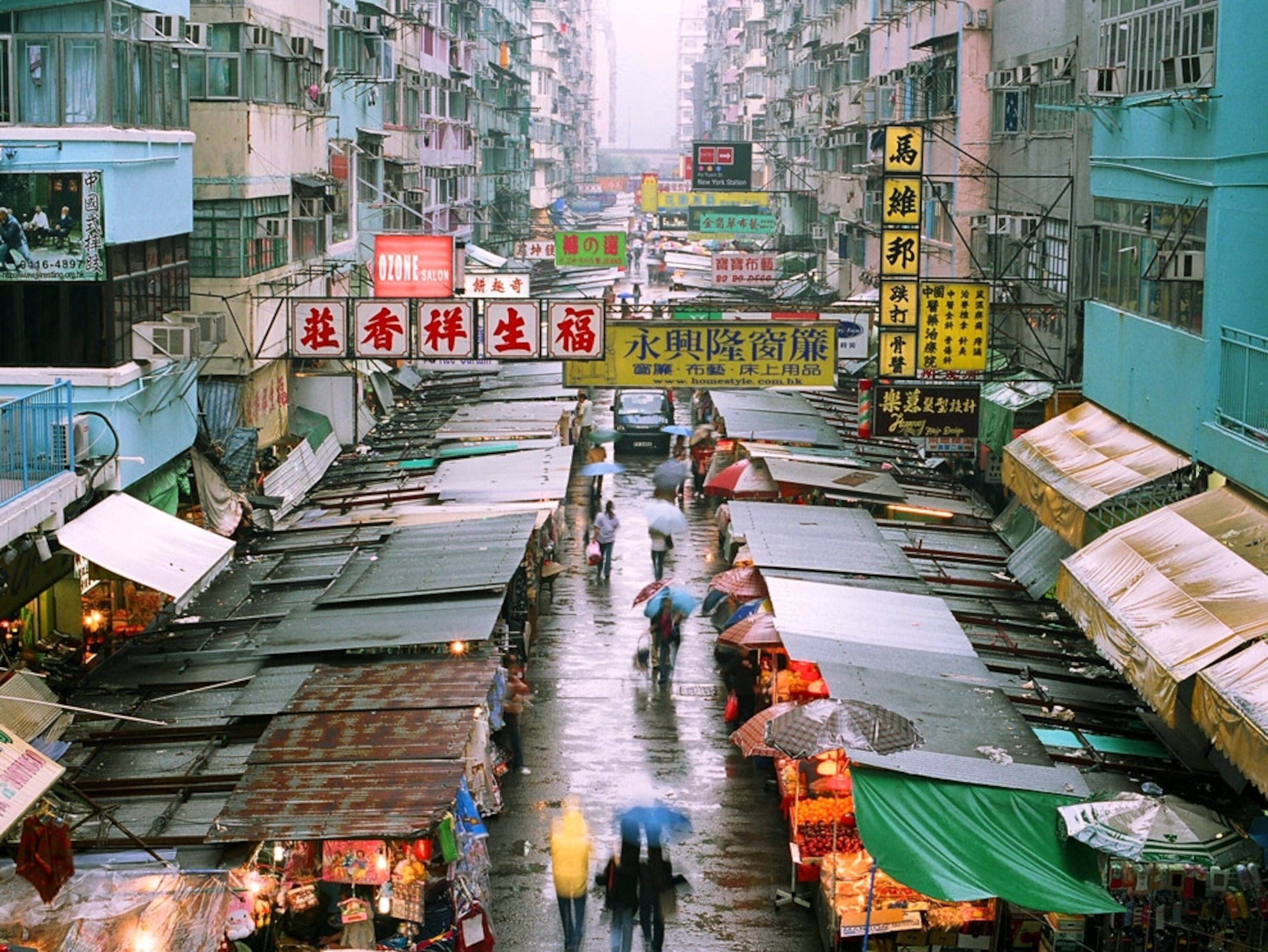 Shoppers walking through a rainy street market