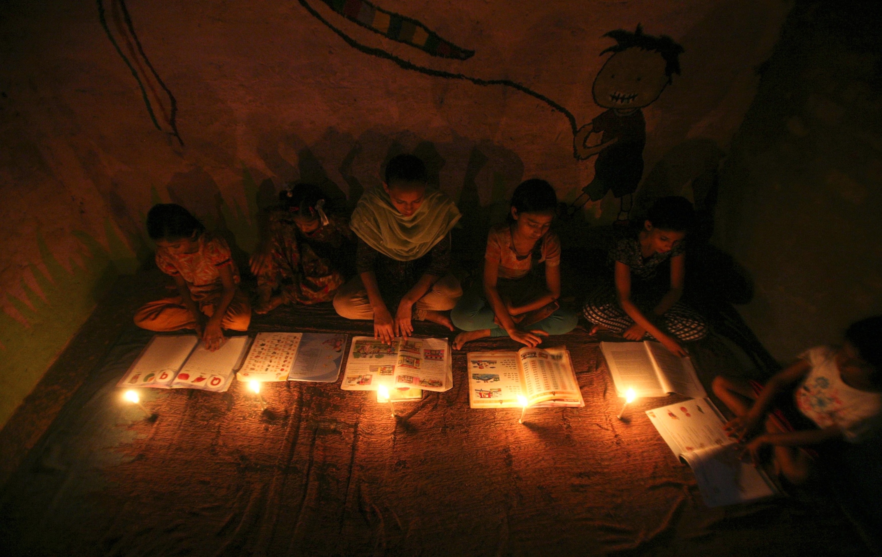India blackout picture: girls study by candlelight in New Delhi