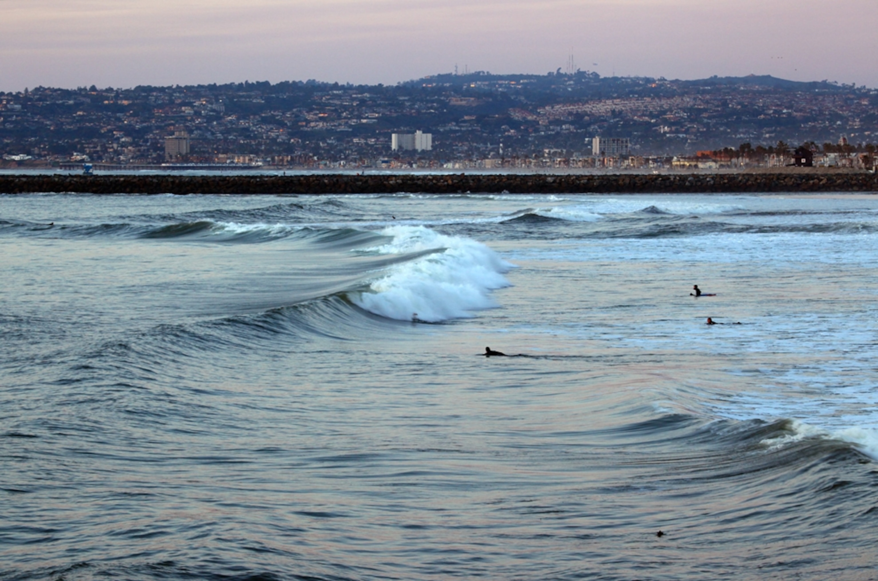 Surfer's paddle out to catch some waves in Ocean Beach, just south of the San Diego River Mouth, where sewage spills happen with some regularity.