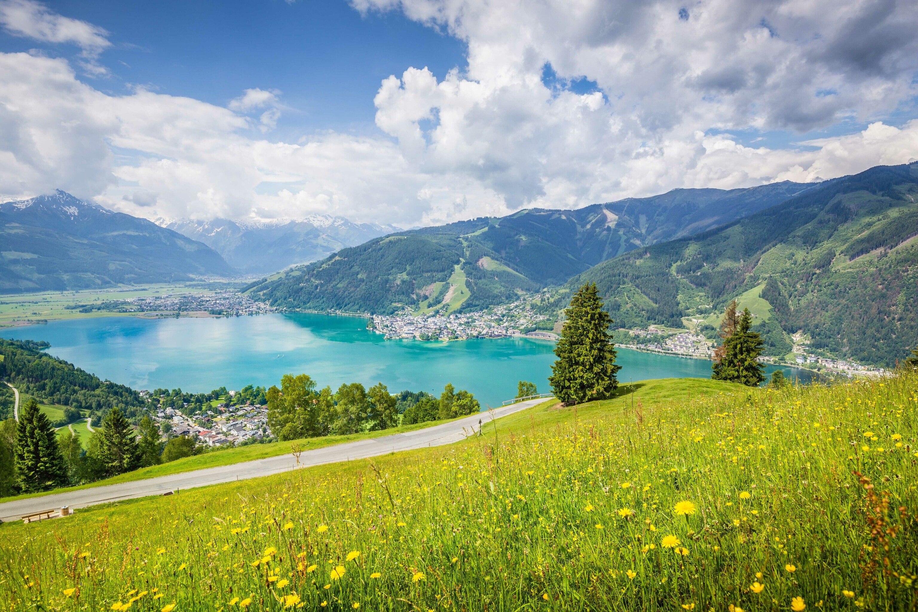 One of Salzburg's many turquoise lakes next to a winding road.
