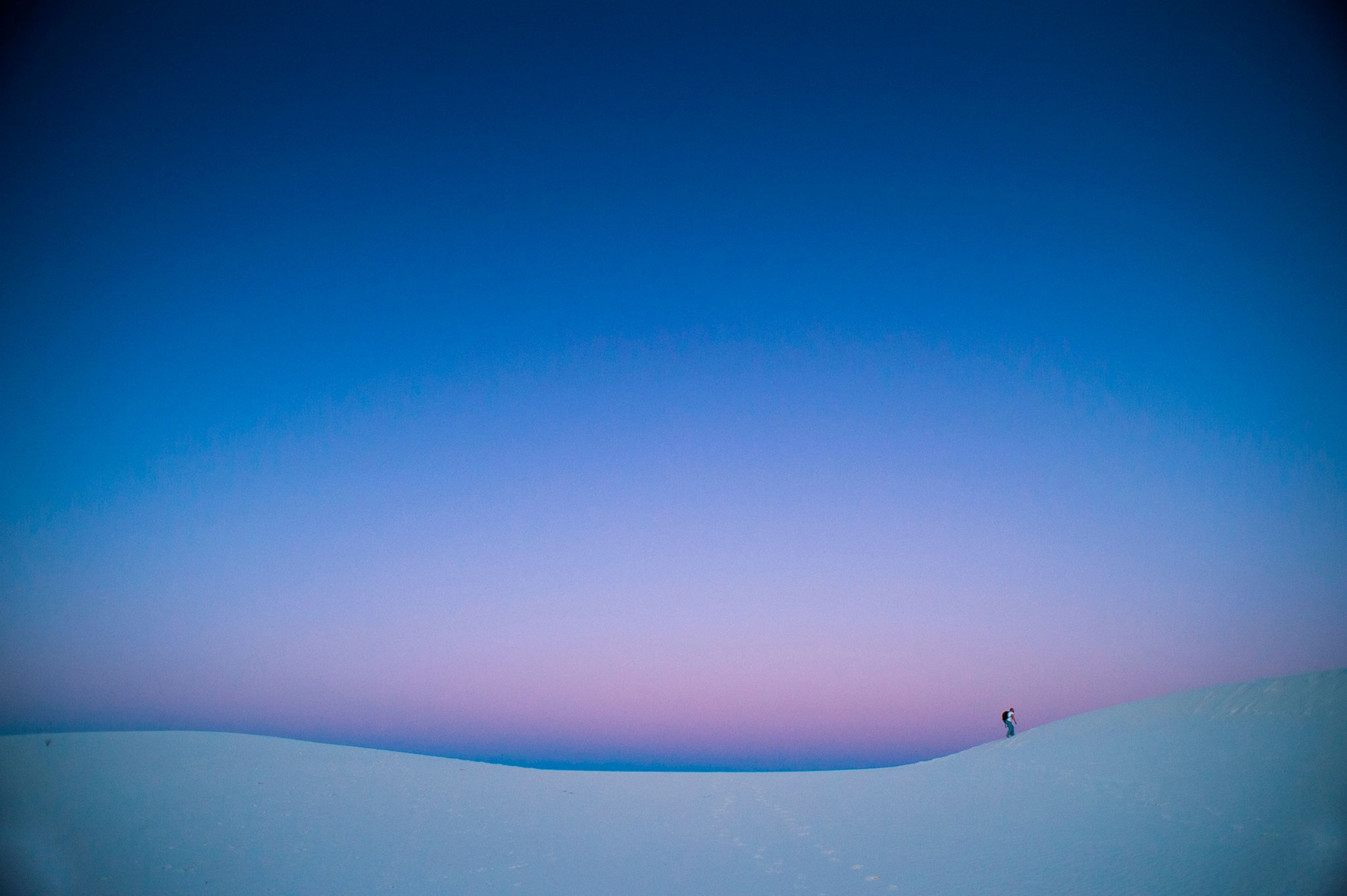 a hiker in White Sand Dunes National Park at dusk in New Mexico