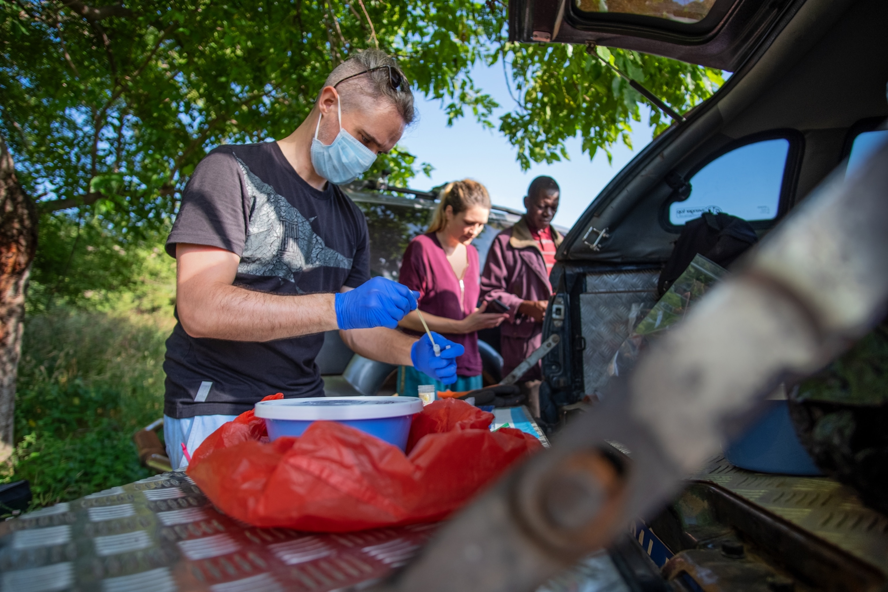 A man processes samples outdoors.