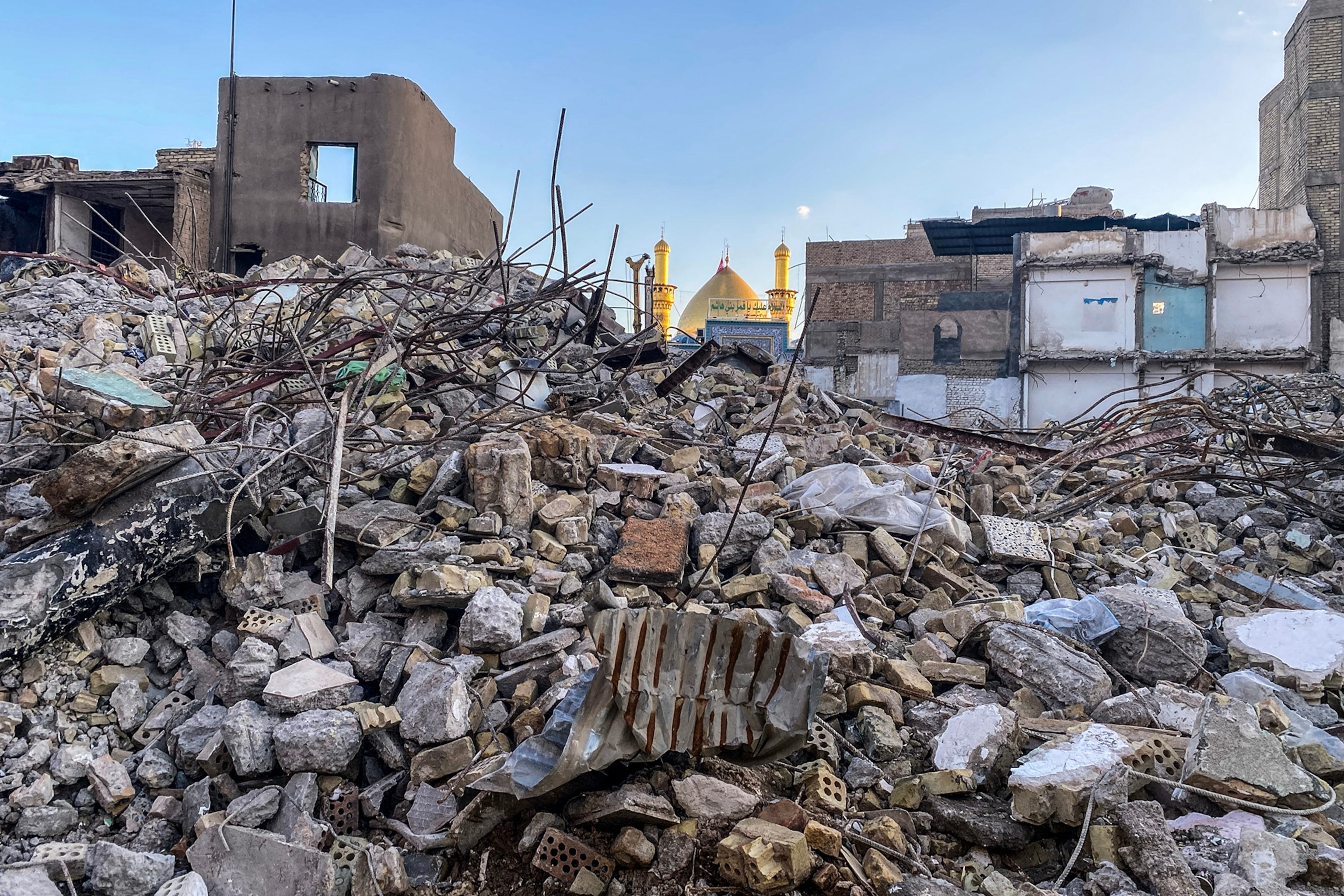 A pile of rubble in front of a golden-domed building