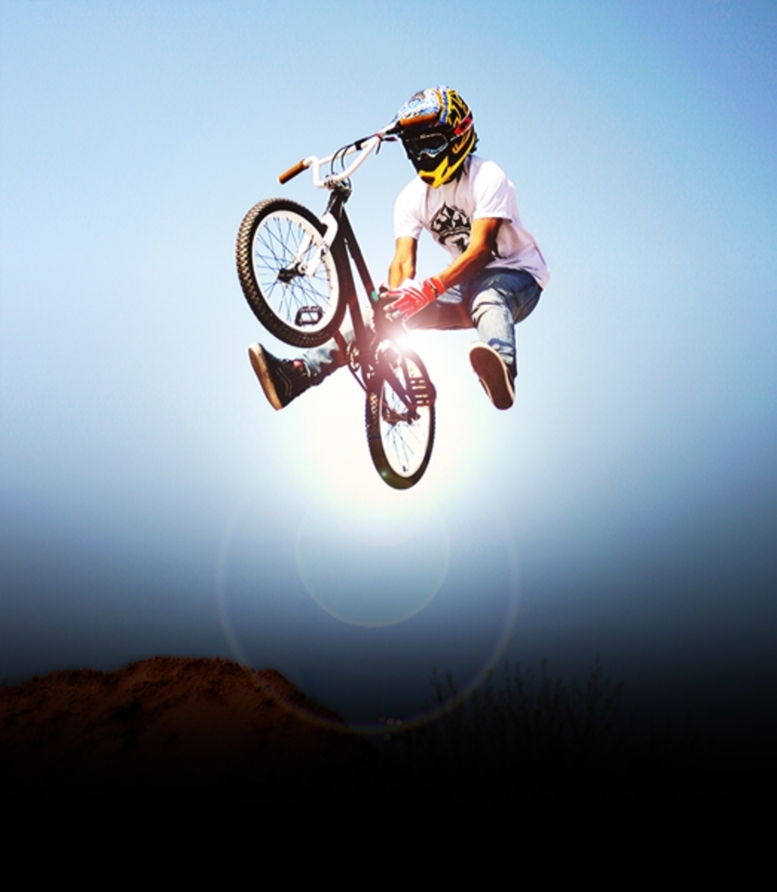 BMX rider performing an air trick over a dirt mound in Las Vegas, Nevada.