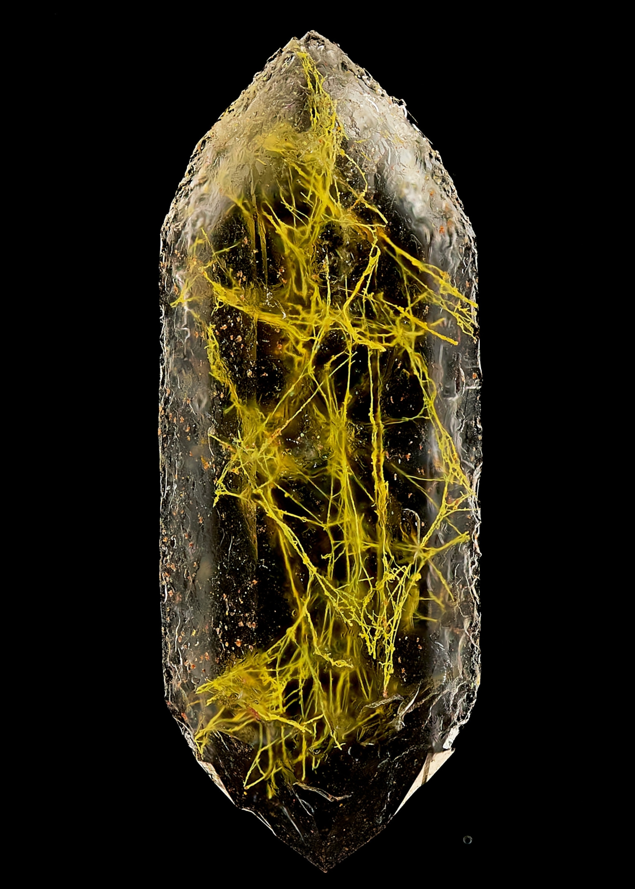 A quartz crystal, inside which a yellow matrix of filaments is trapped