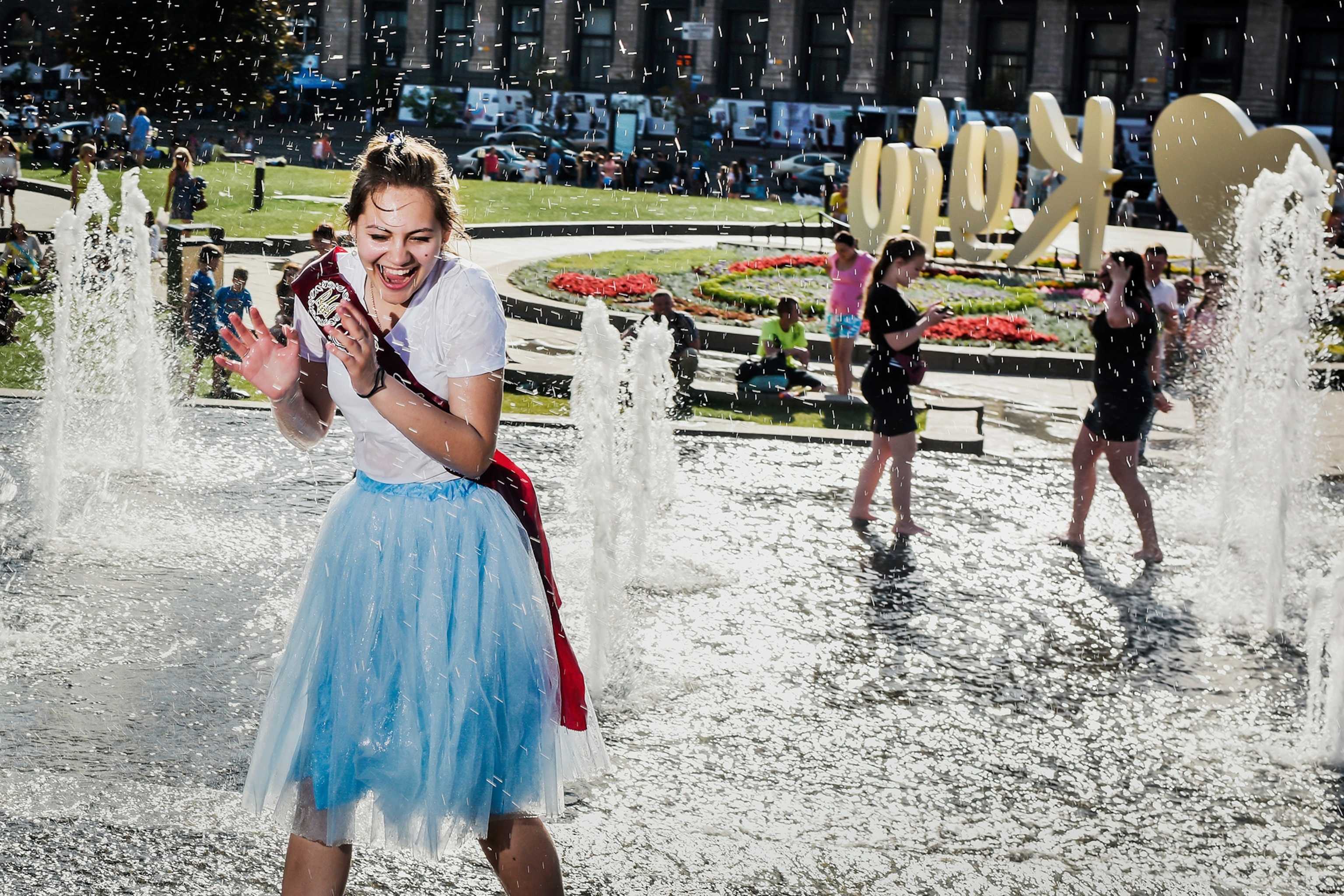 a student playing in a fountain on the last day of school in Kiev, Ukraine