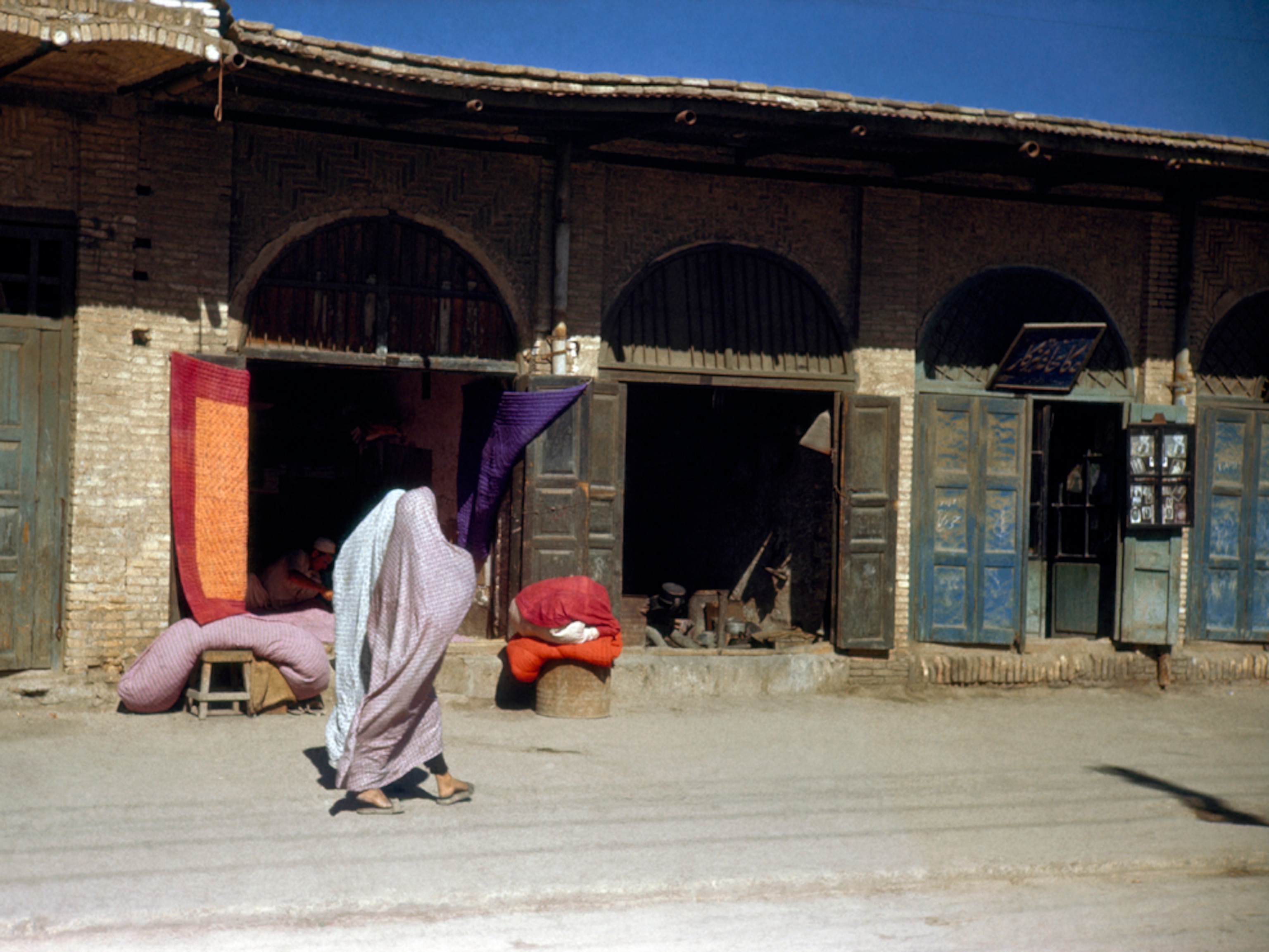 Cloaked women walking through a bazaar