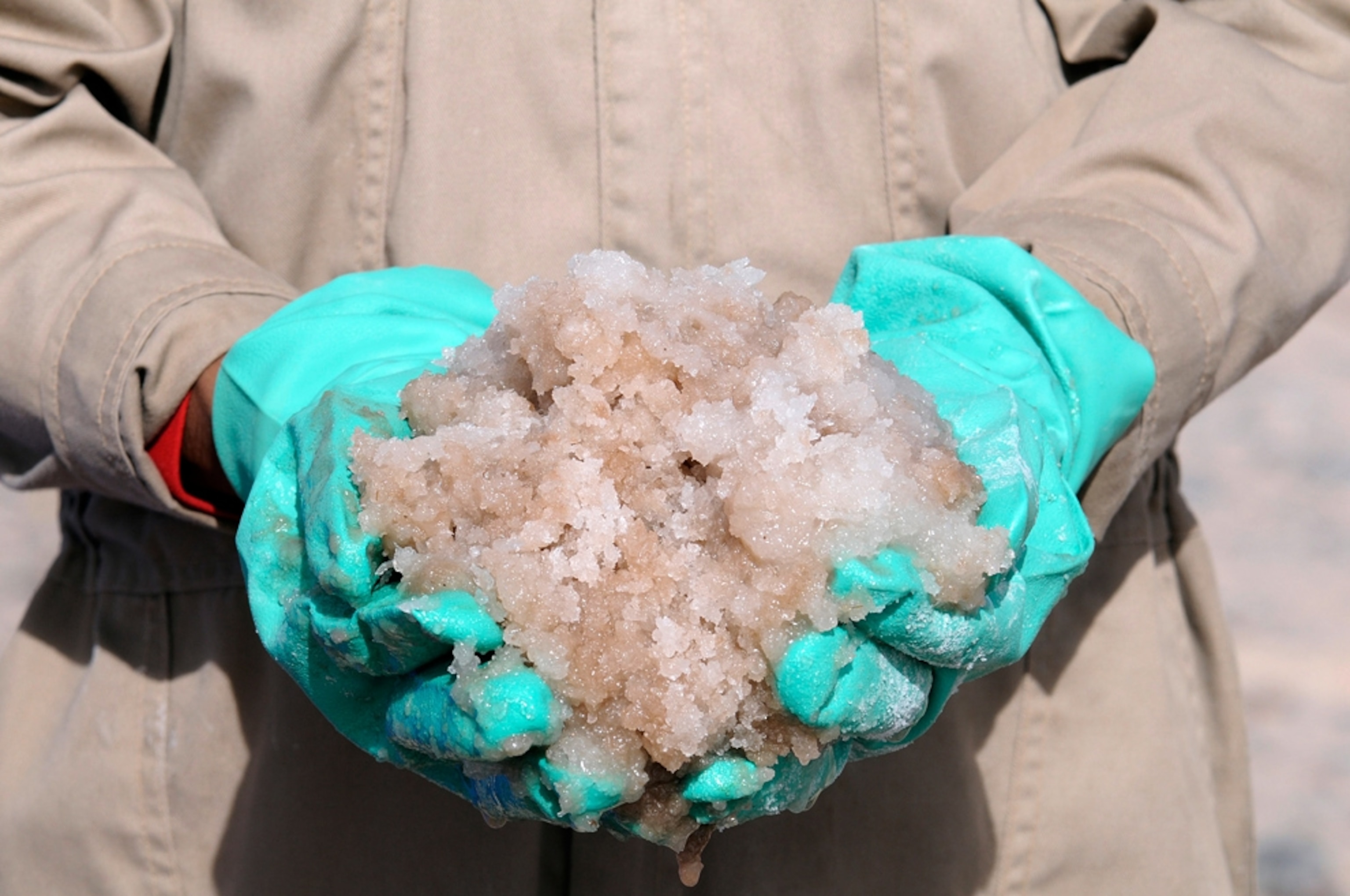 A Bolivian worker holds raw materials at the lithium extraction factory in the Salar de Uyuni