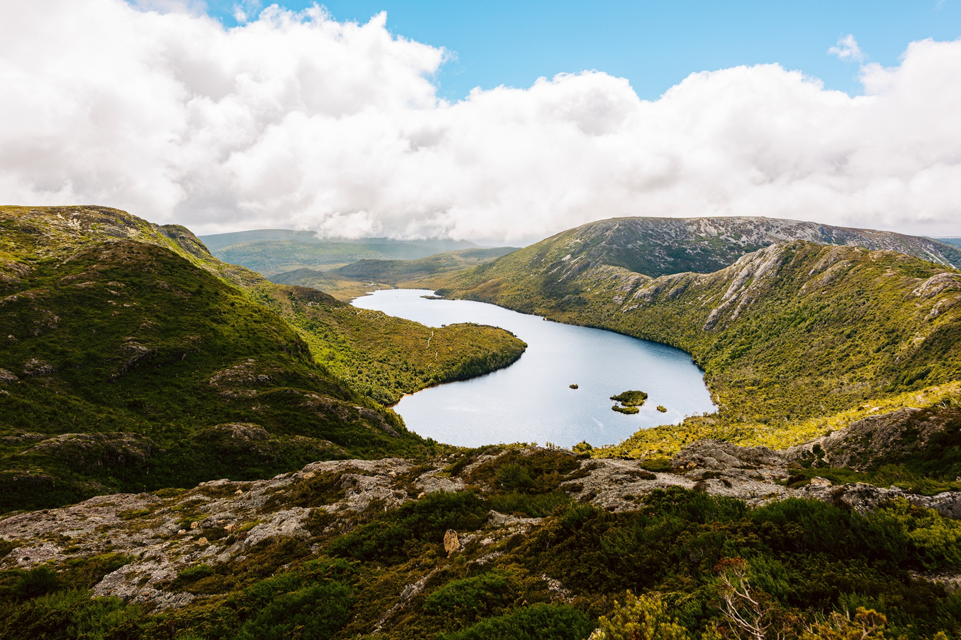 A mountainous landscape shot with mossy forests and a central lake.