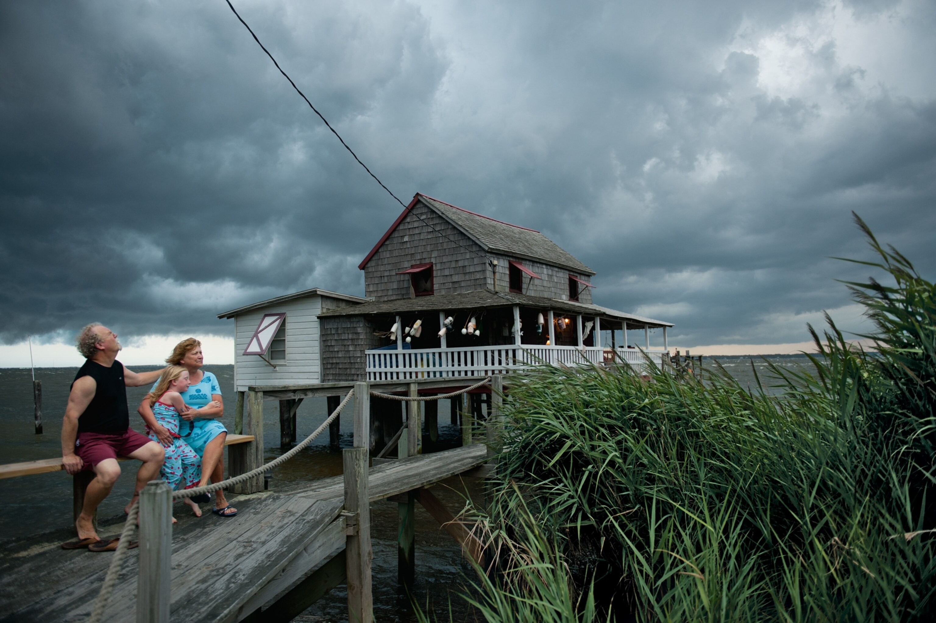 a family watching a squall roll over their house on Roanoke Sound