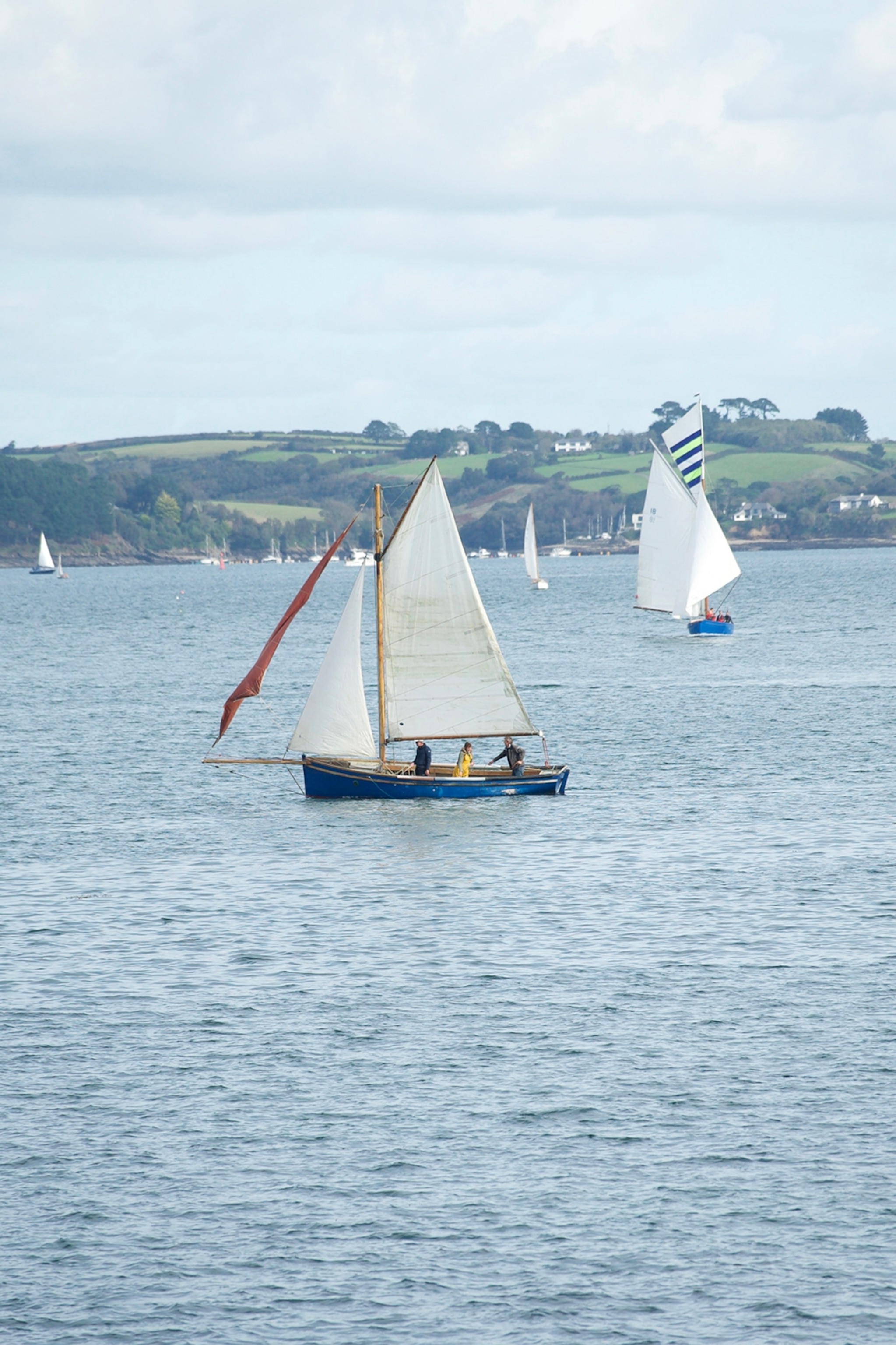 A pair of sailing boats out on the British sea.