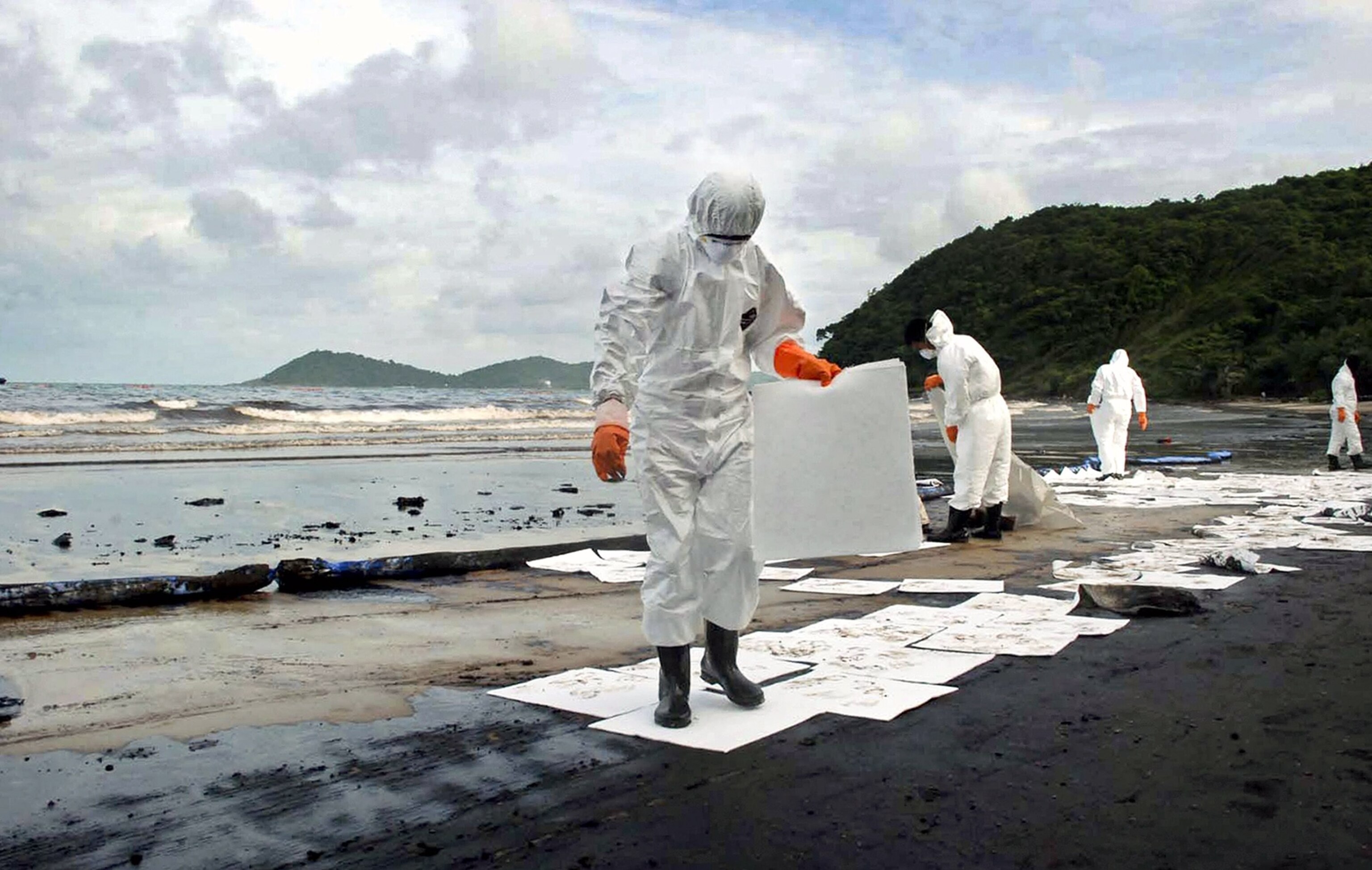 Oil-absorbing sheets are laid on the sand at Samet Island, where gallons of spilled crude oil have washed ashore.