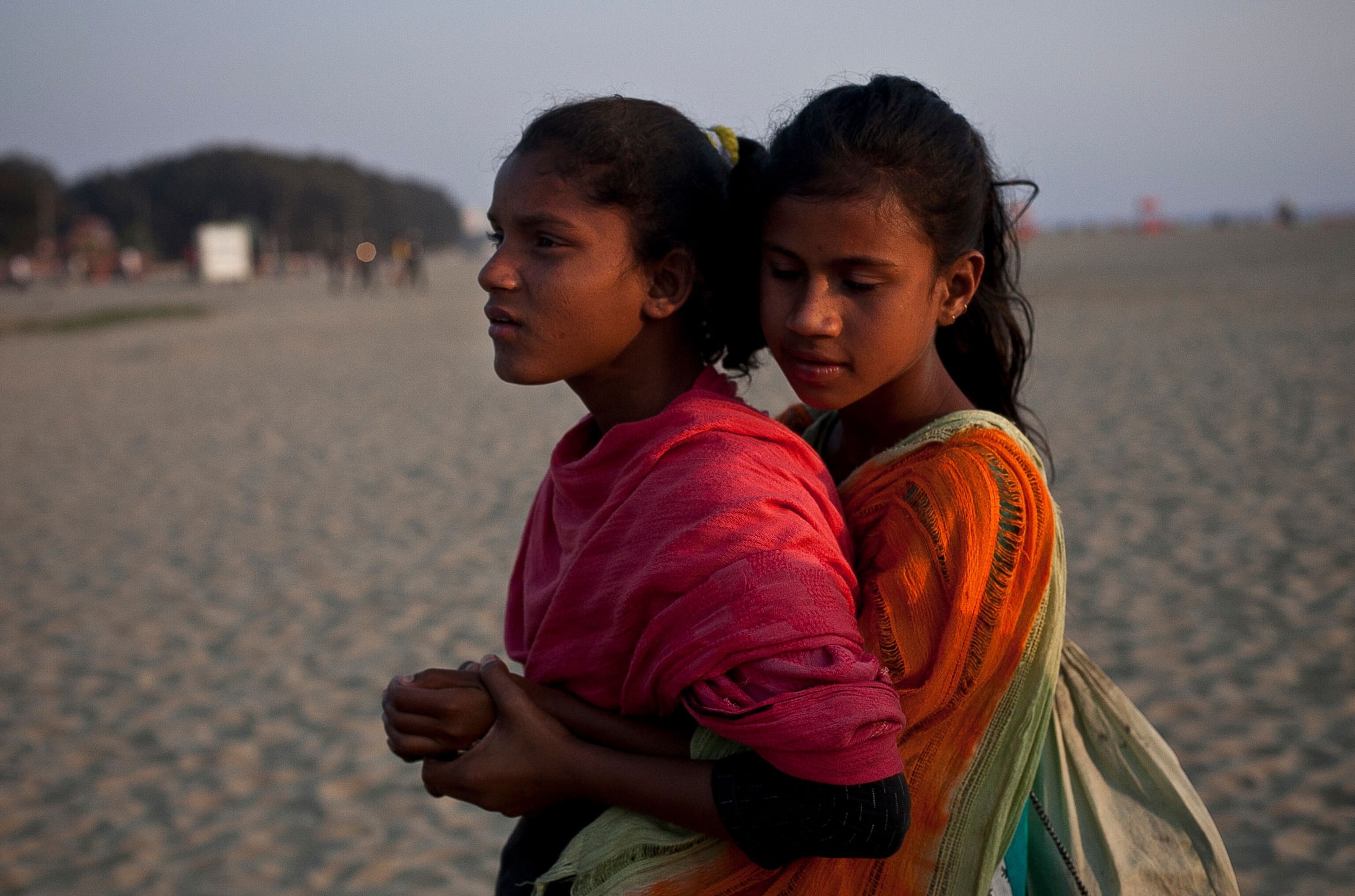 Shobe Majaraz, 12, hugs Suma, 12, on the beach.