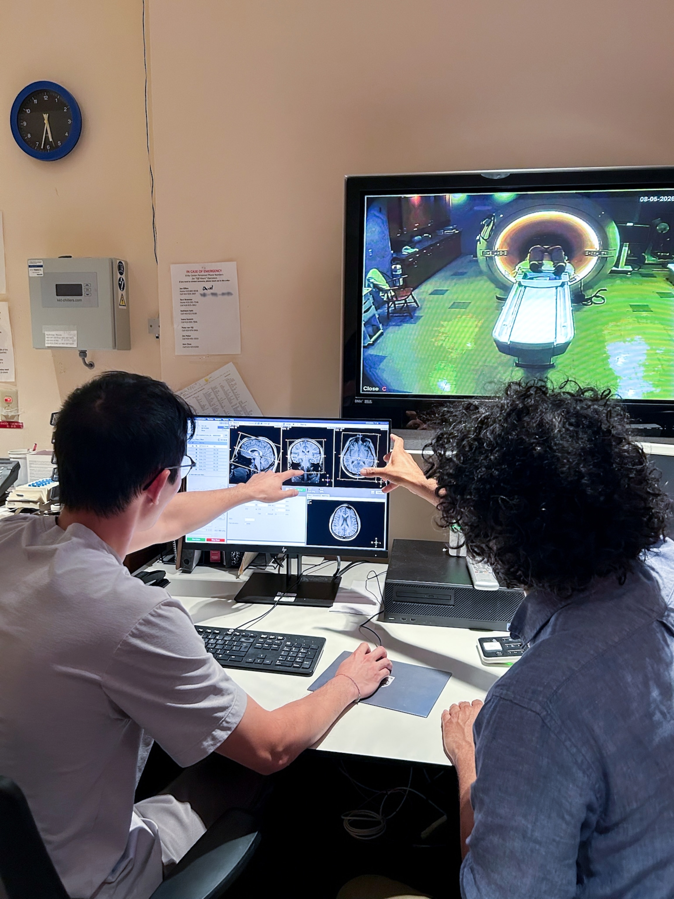 Two people look at a monitor that have scans of a brain