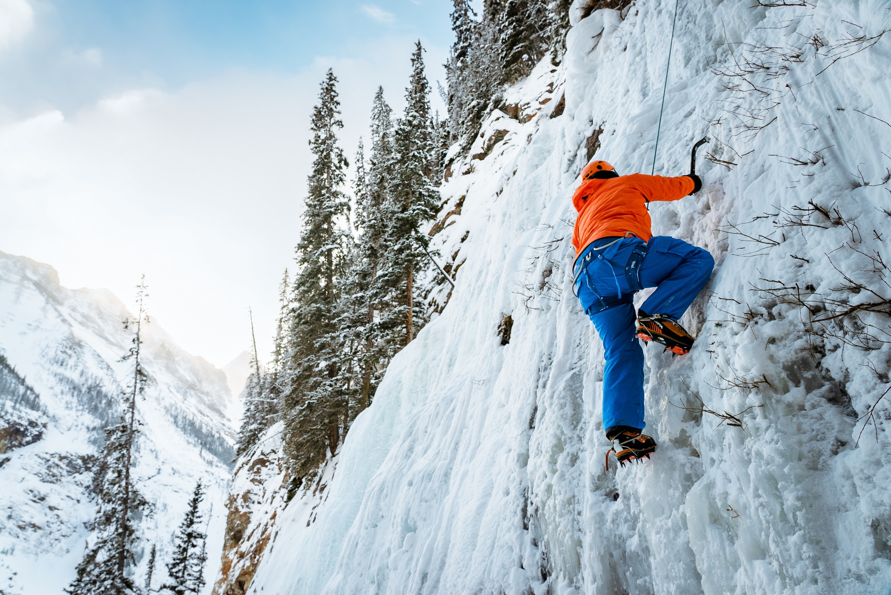An ice climber travels up a frozen waterfall.