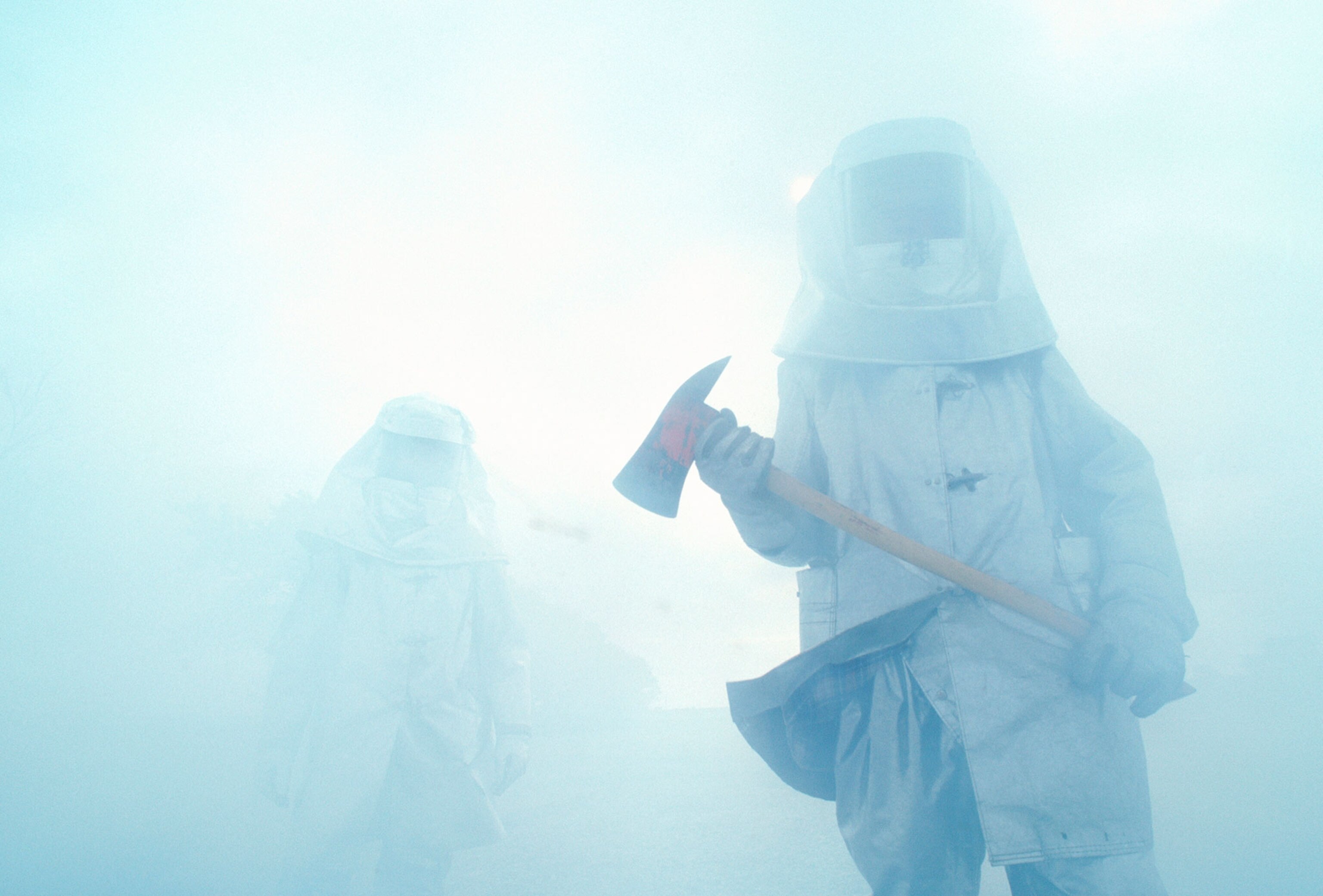 Firefighters carrying axes walk through a blanket of thick smoke in Texas