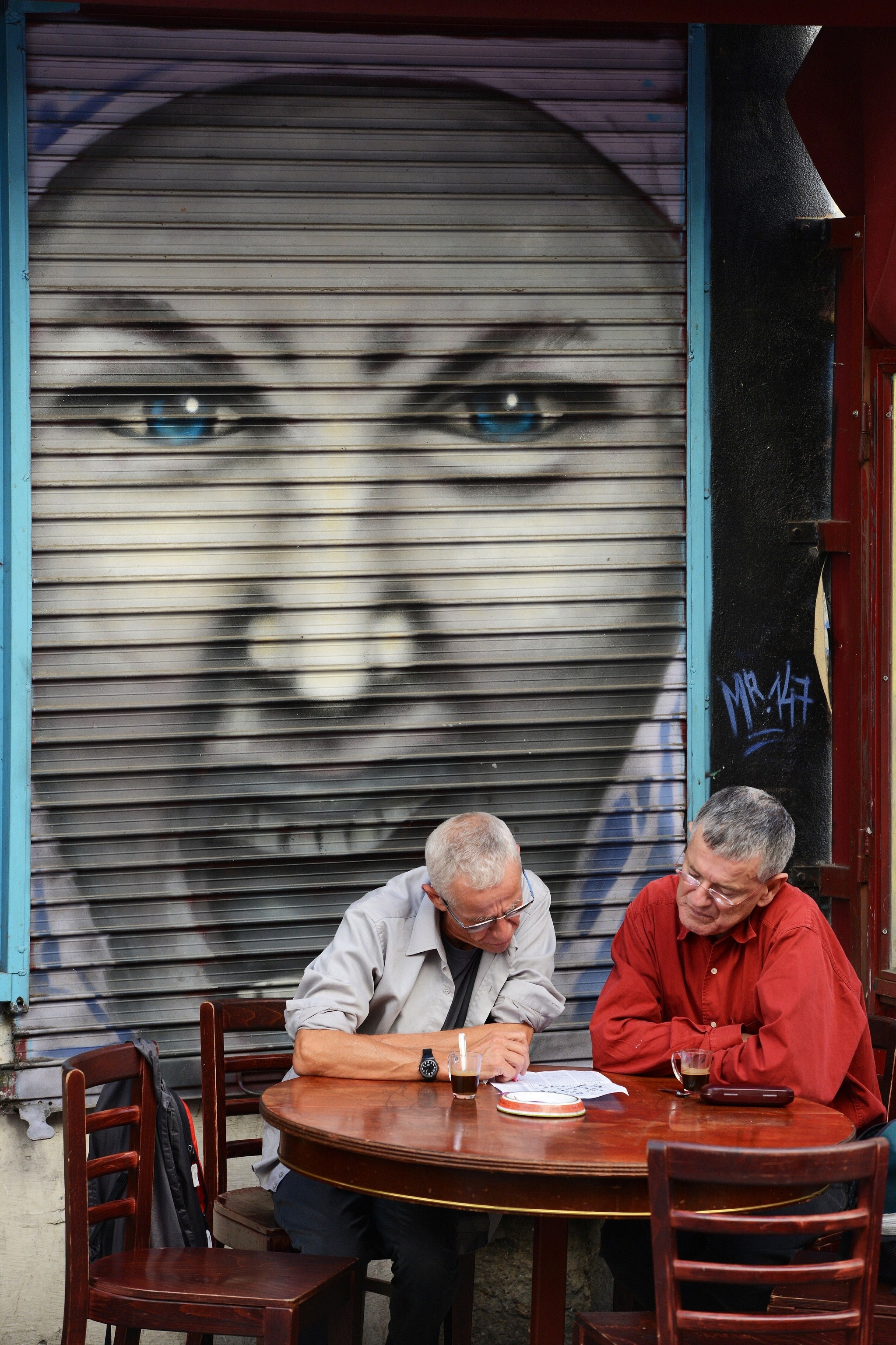 Men pause for a coffee and a puzzle on Rue Denoyez in Belleville.