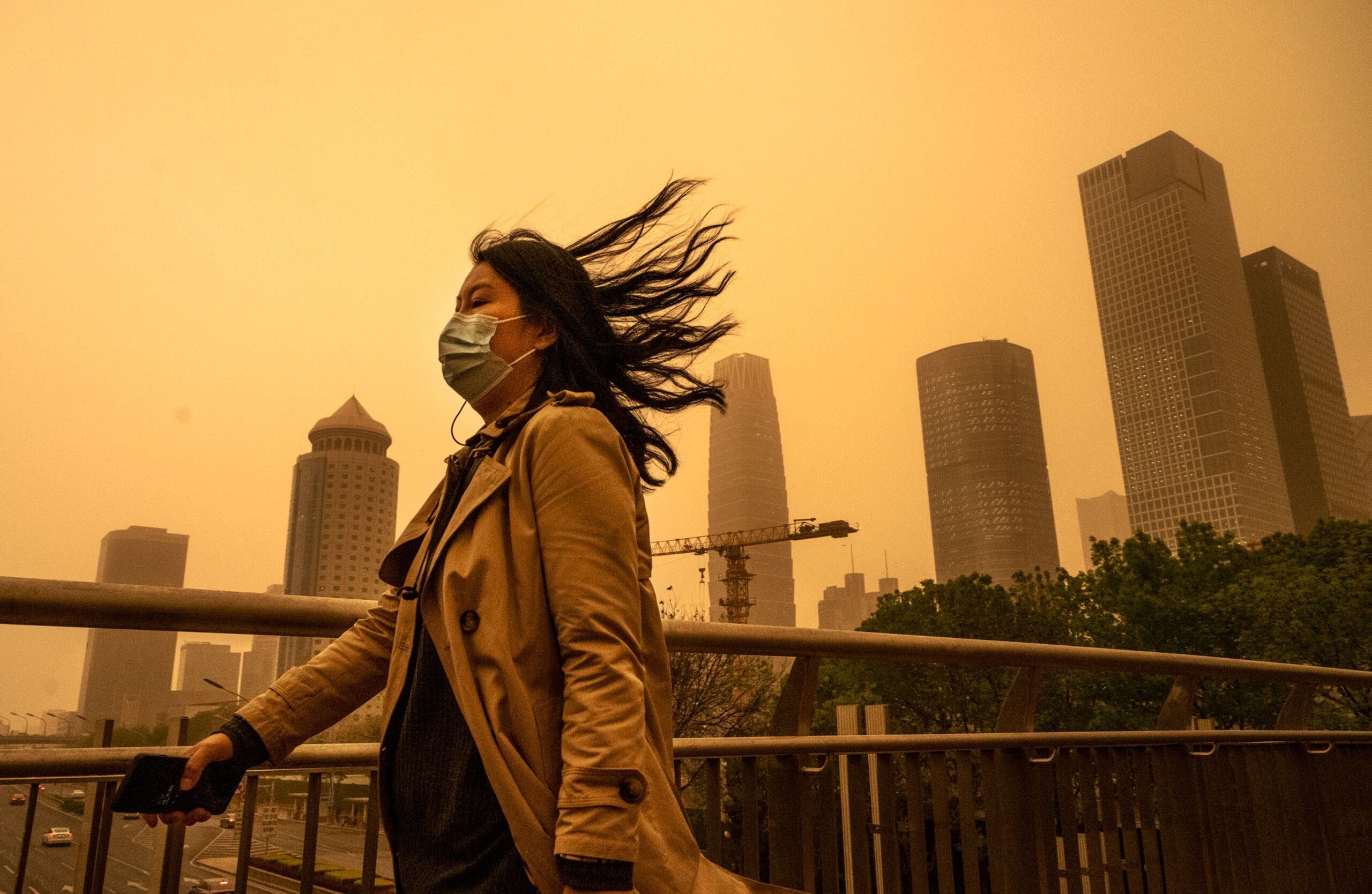 A woman walk through a sandstorm in Beijing, China.