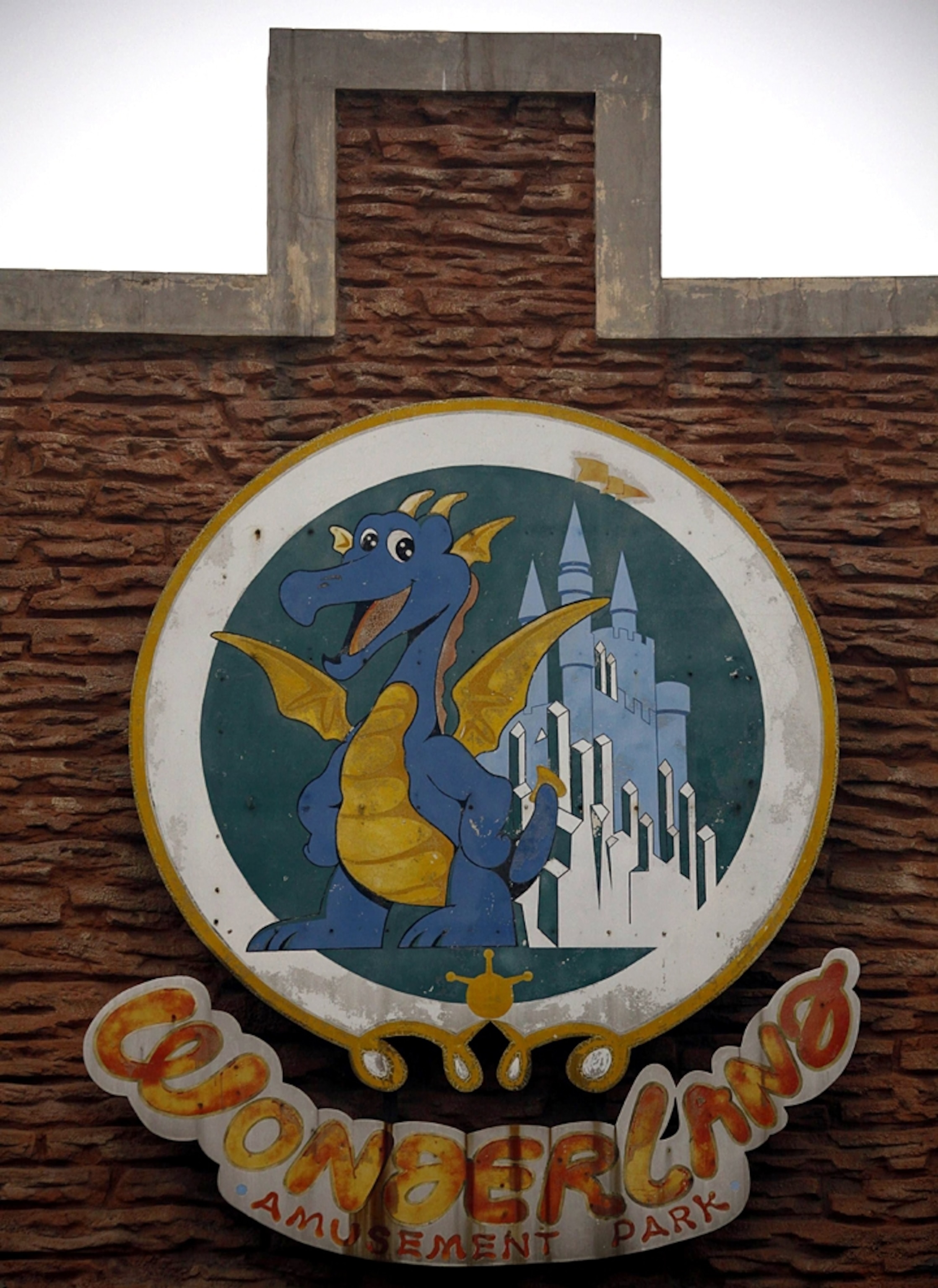 Wonderland sign picture: a sign hangs on an abandoned building, for a gallery on Wonderland, an abandoned project to build a Disney style amusement park outside of Beijing, China