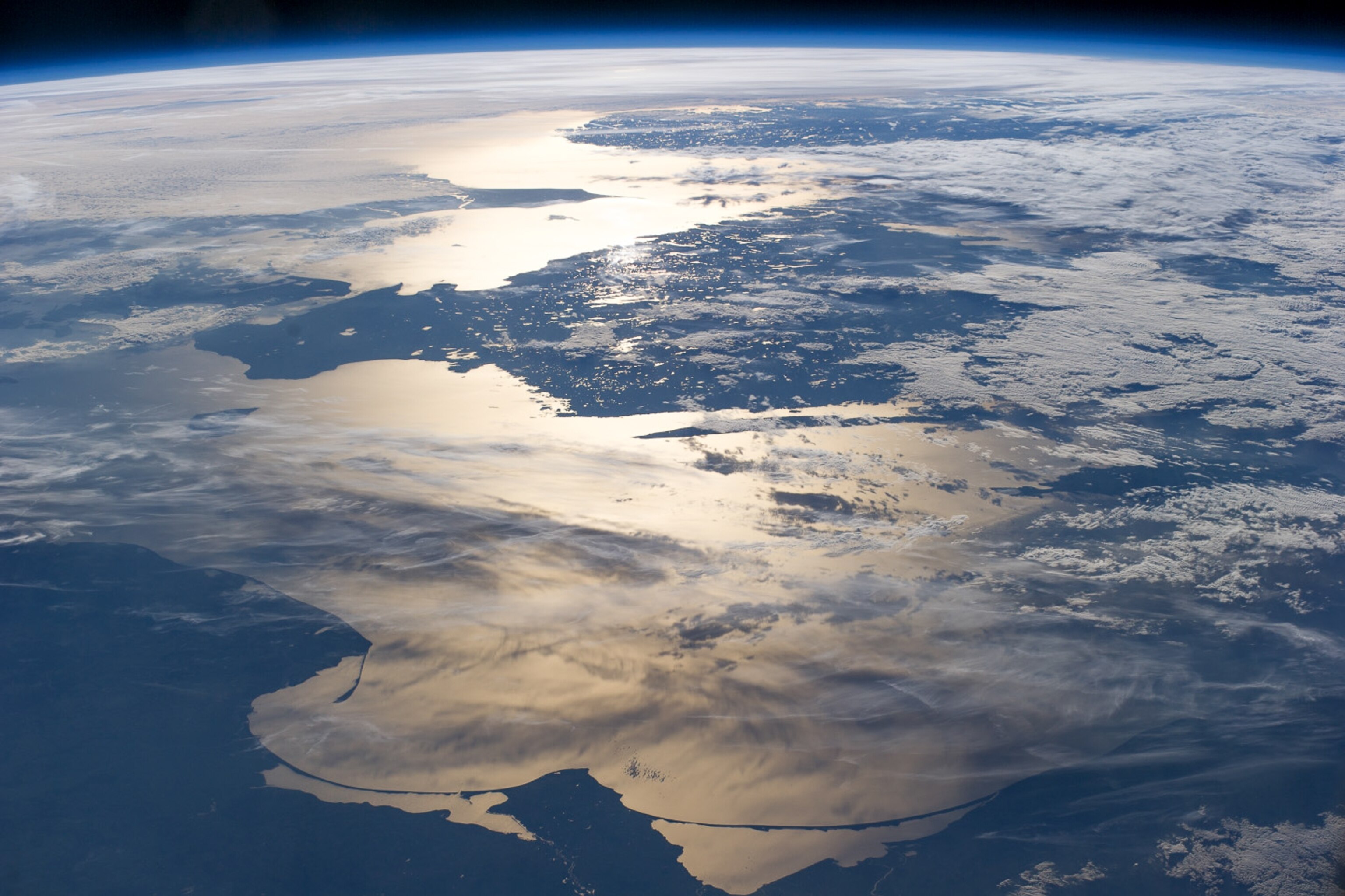 A panoramic photo of earth as the sun sets over the North Sea.