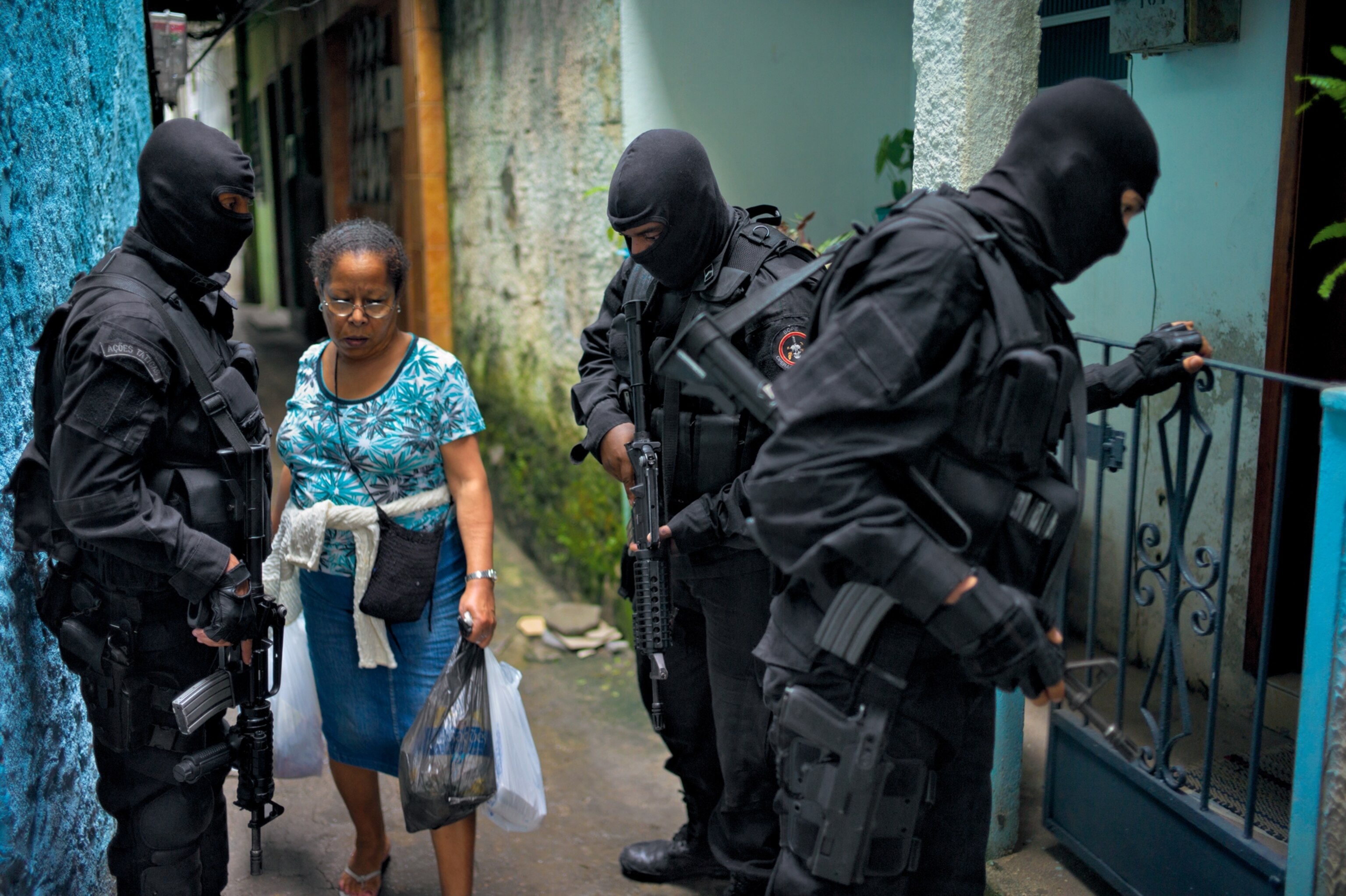 a favela resident passing military police taking part in a training exercise