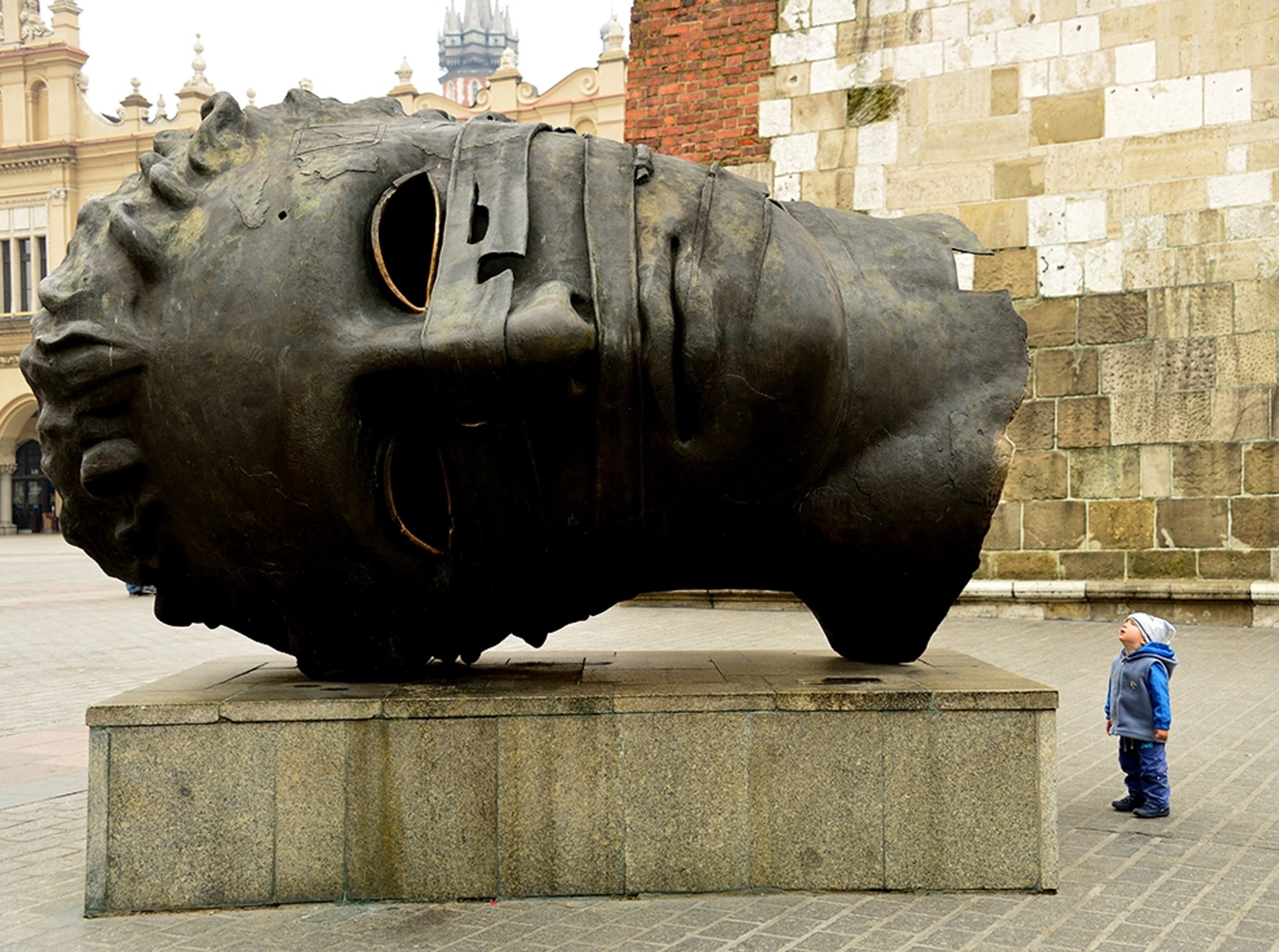 a child staring at a statue in Krakow, Poland