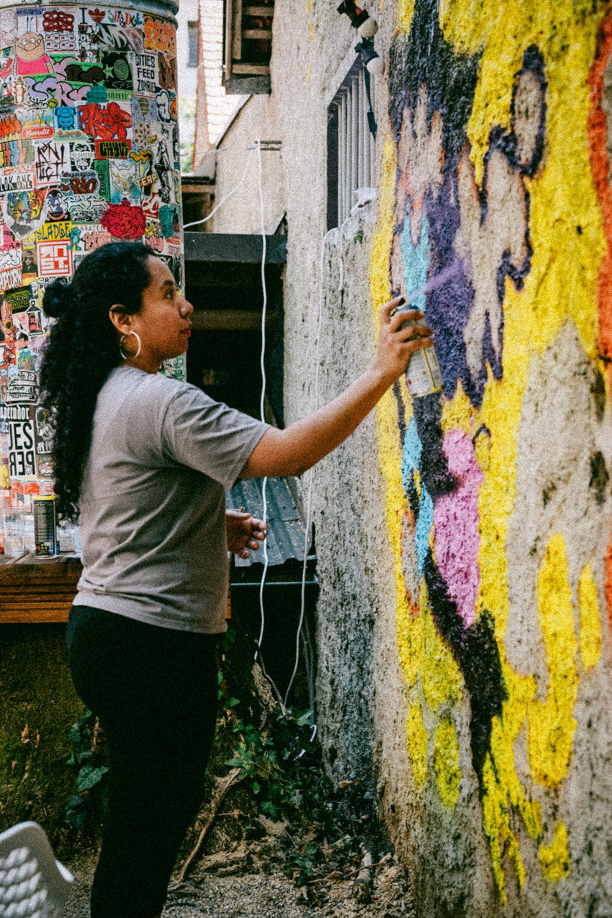 A local woman spray-painting a wall.