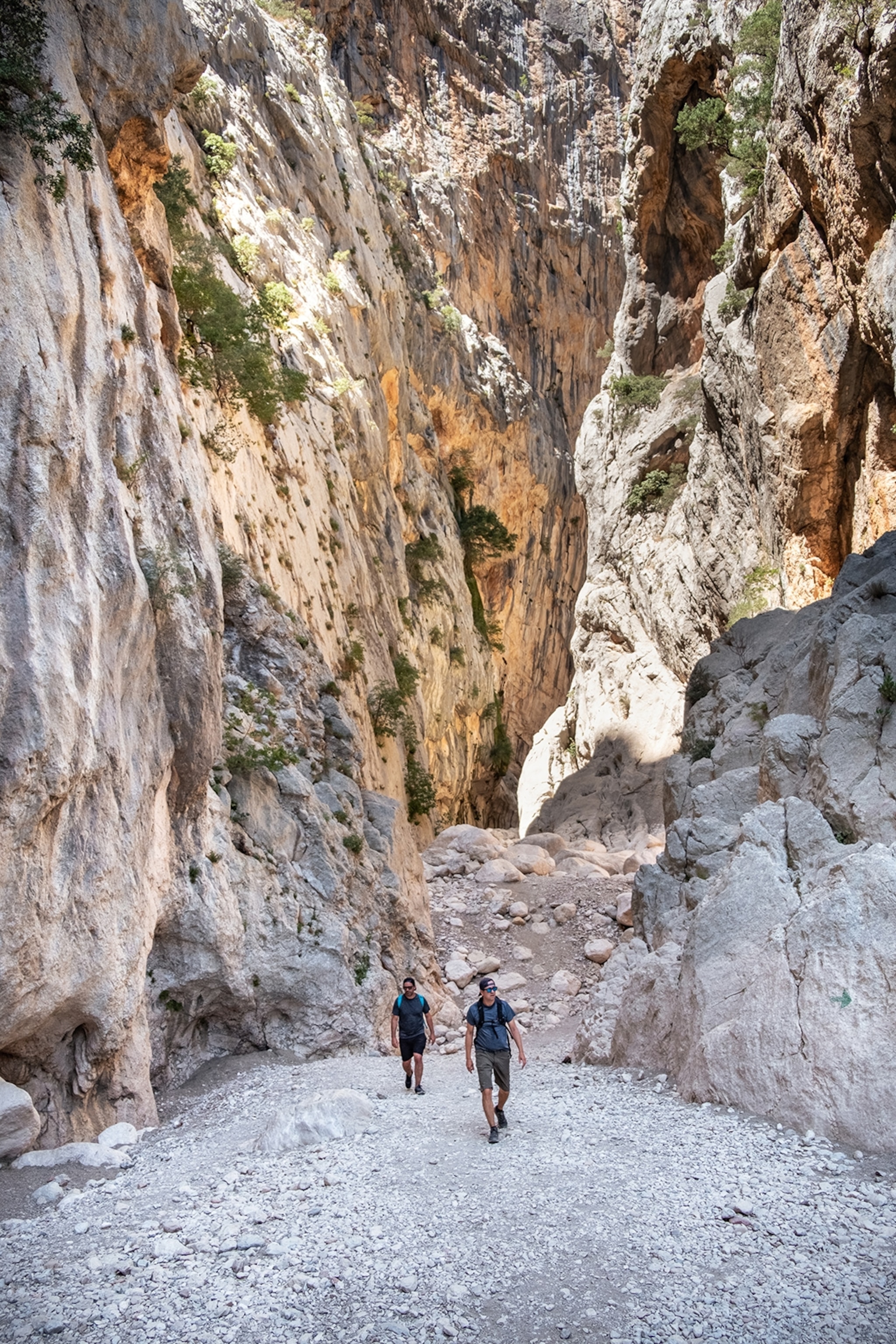 Surrounded by cliffs, two men hiking.