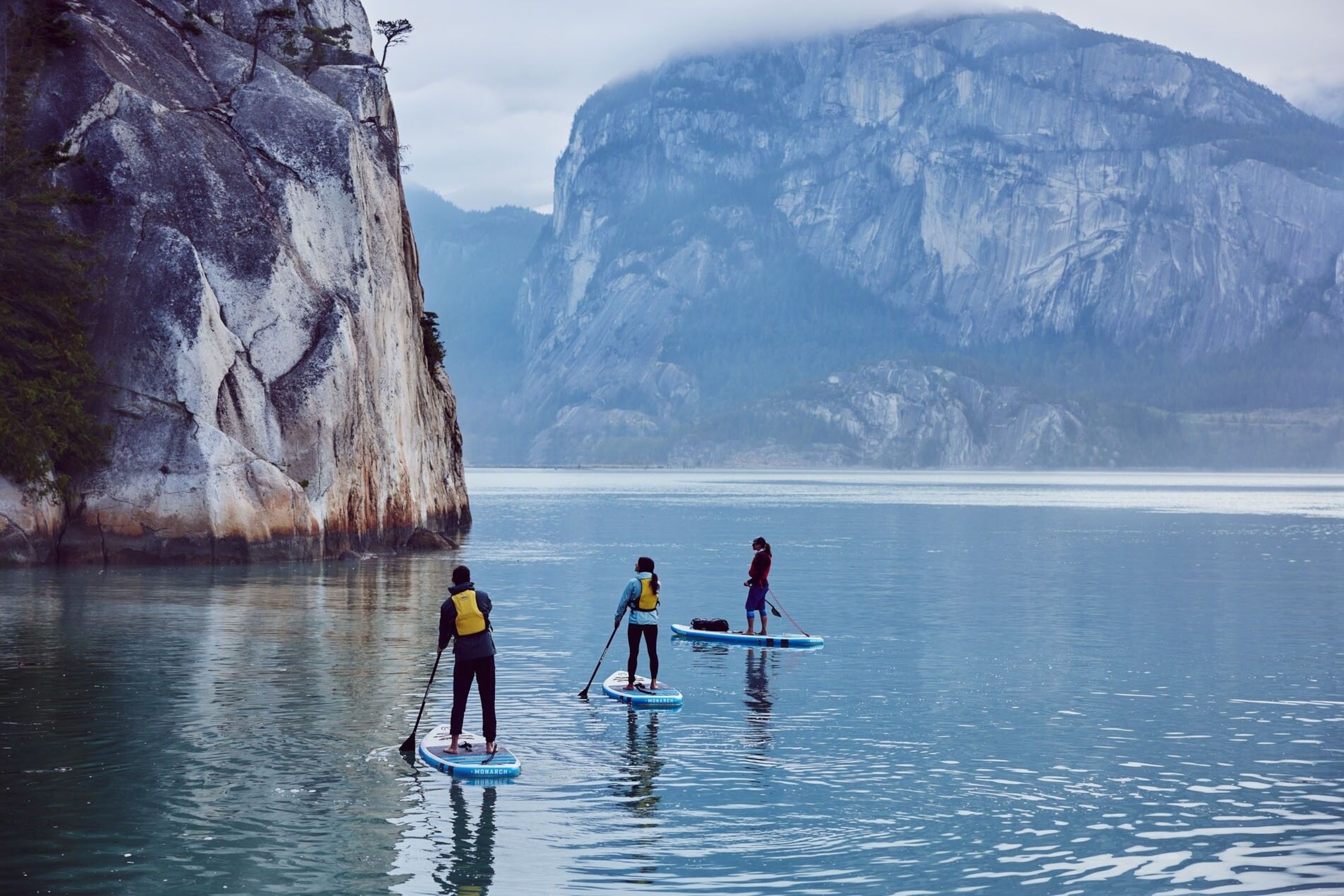 Stand-up paddleboarding on a lake with imposing mountain views