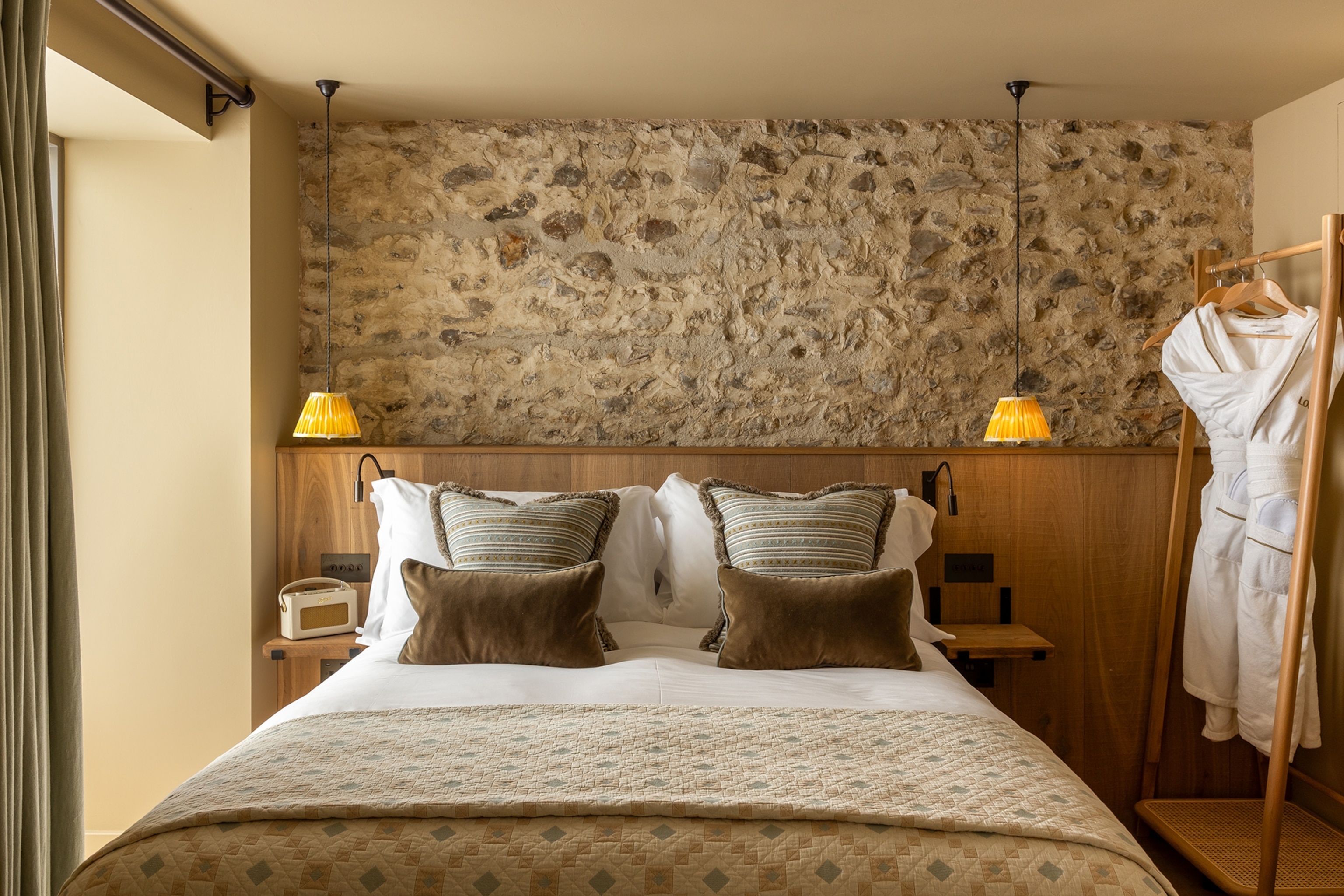 A double bedroom with warm and low lighting on either side of the bed.