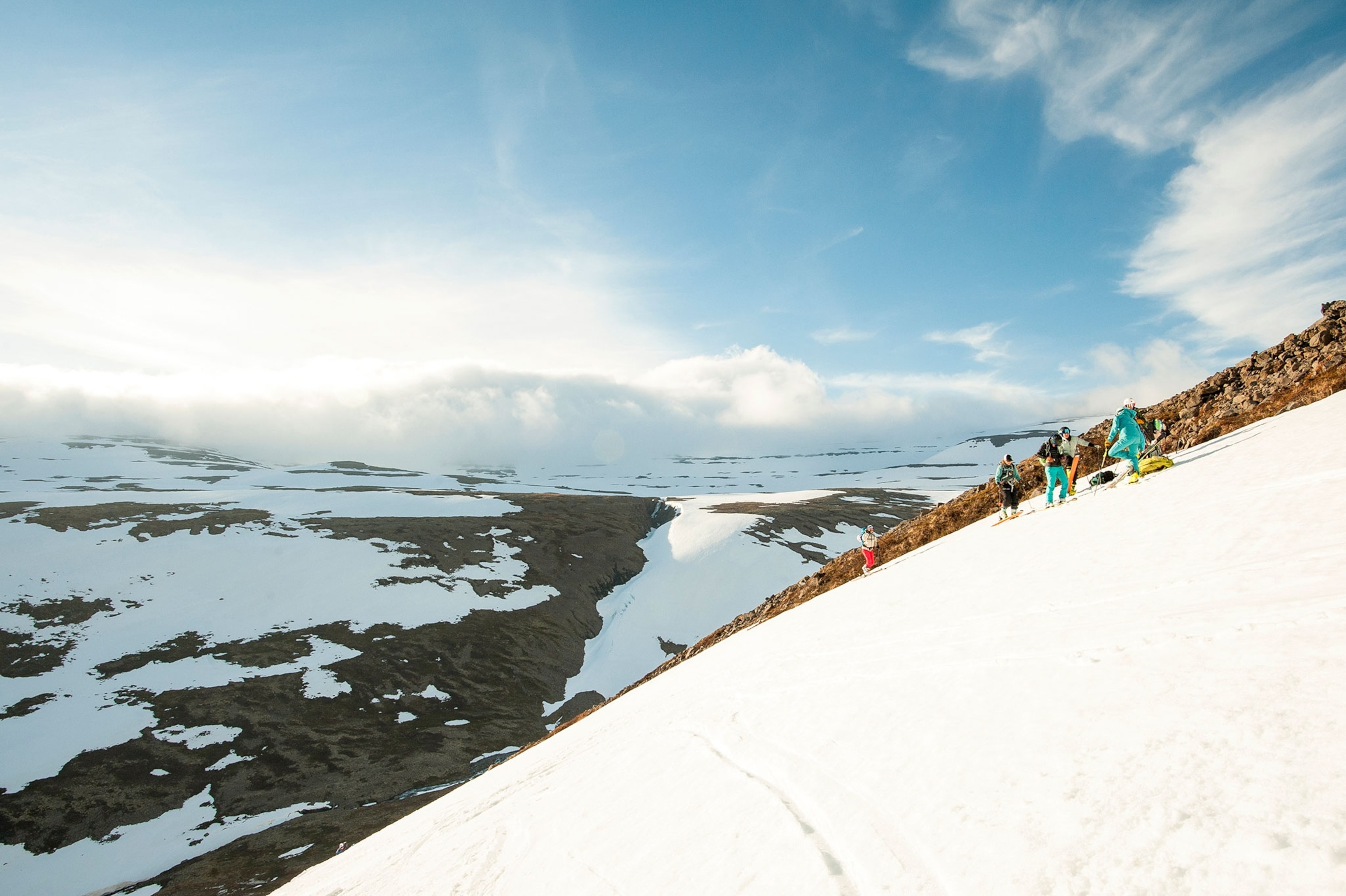 a group of skiers hiking up a hill in Iceland