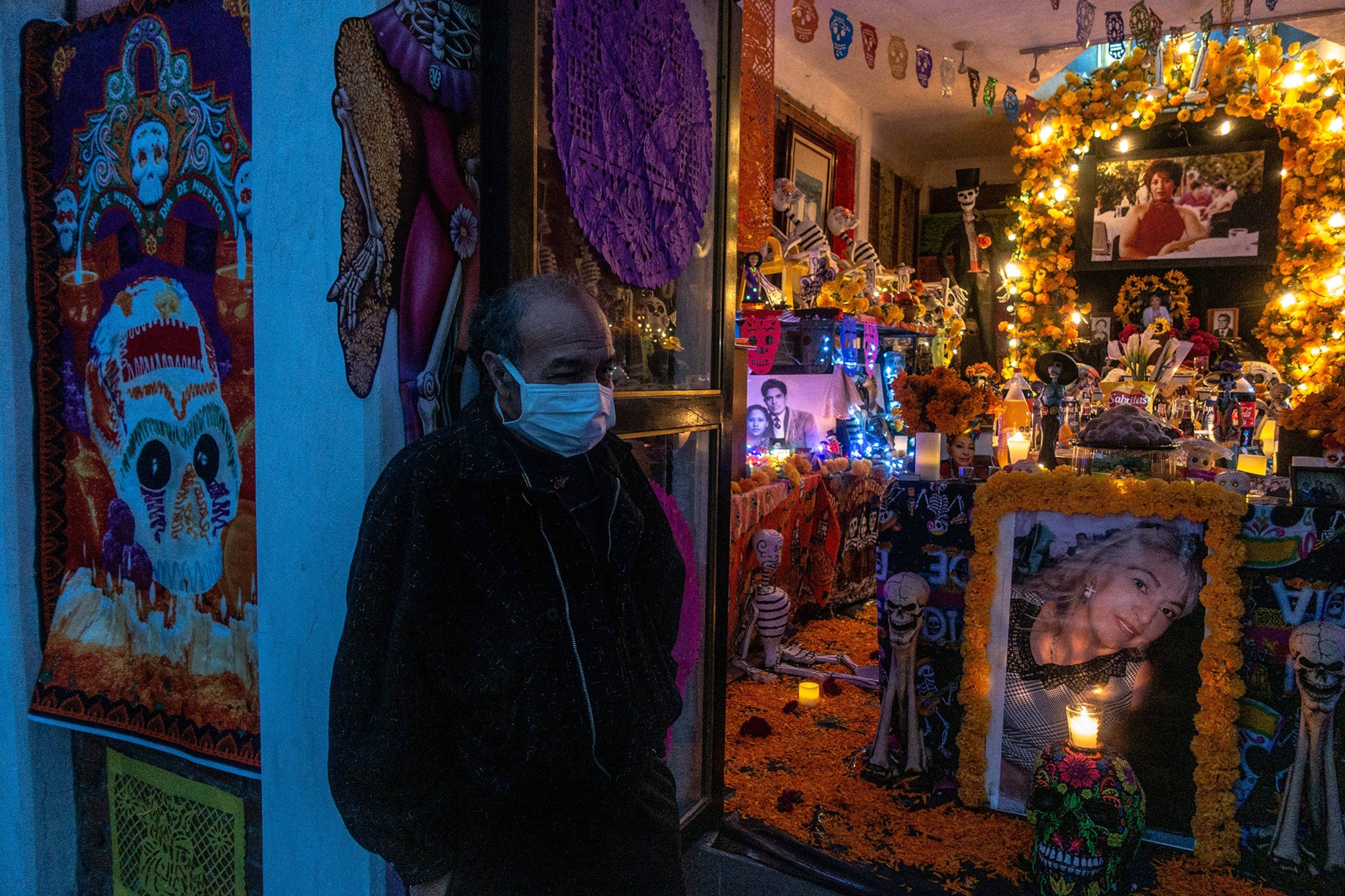 a man stands outside an altar to honor his wife, who died of COVID, in Mexico