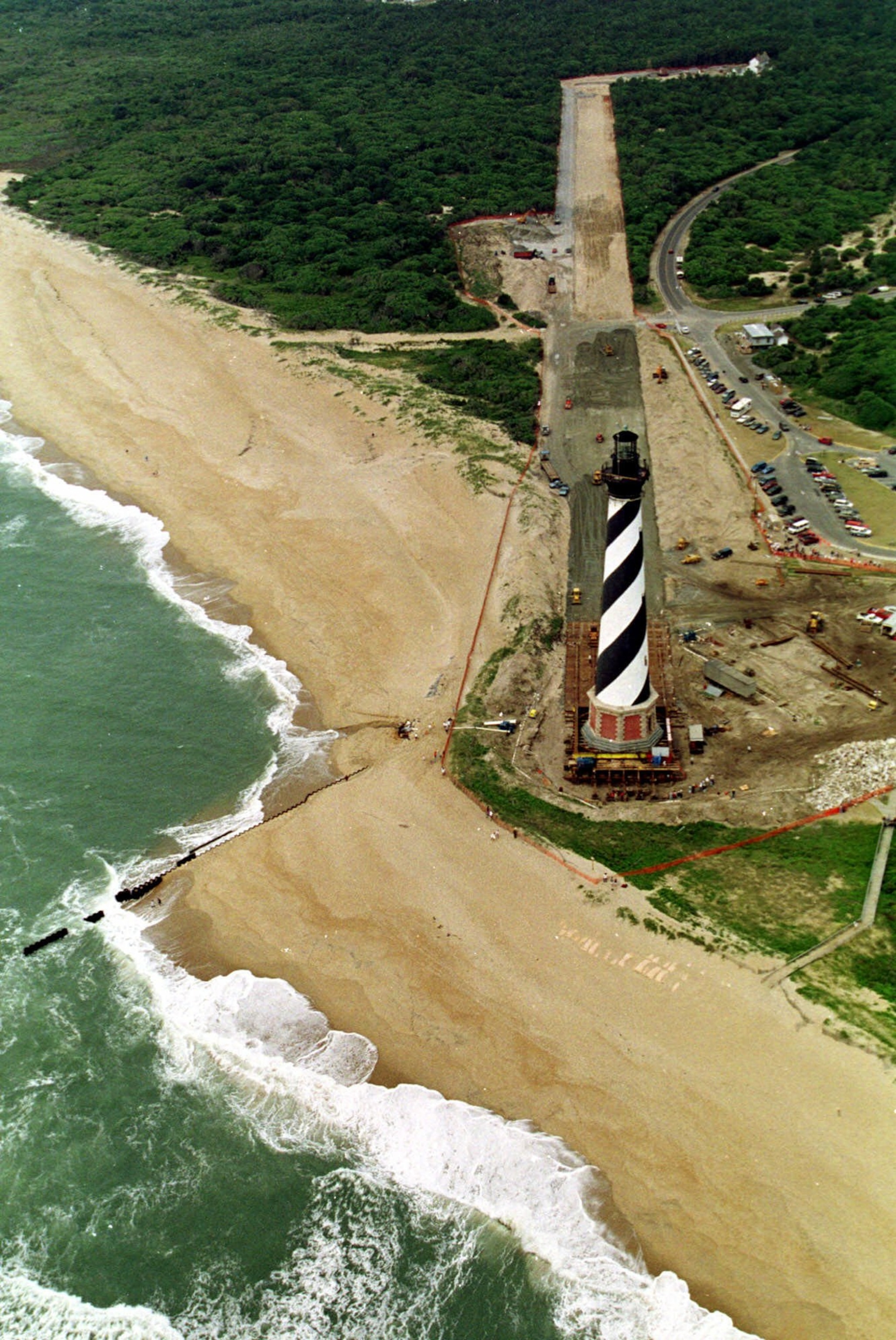 Waves crash along the beach as engineers continue to move the Cape Hatteras Lighthouse in Buxton N.C., Friday June 18, 1999. Workers are rushing to move the lighthouse 1,800 of the total 2,900 feet of the move to protect it from beach erosion. When completed the lighthouse will be set on a new base at the top of the photo.