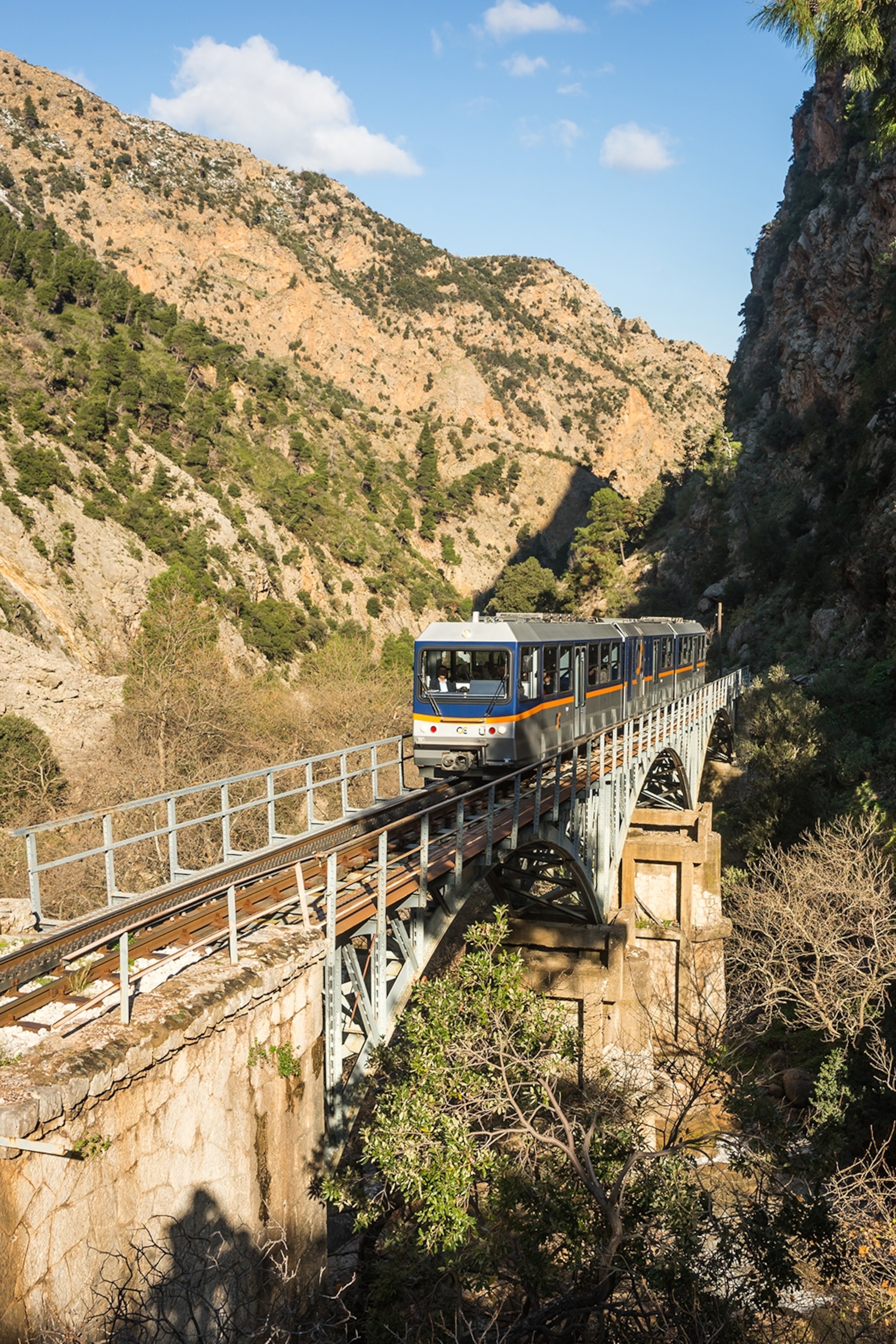 A train emerging from between a mountain gorge.