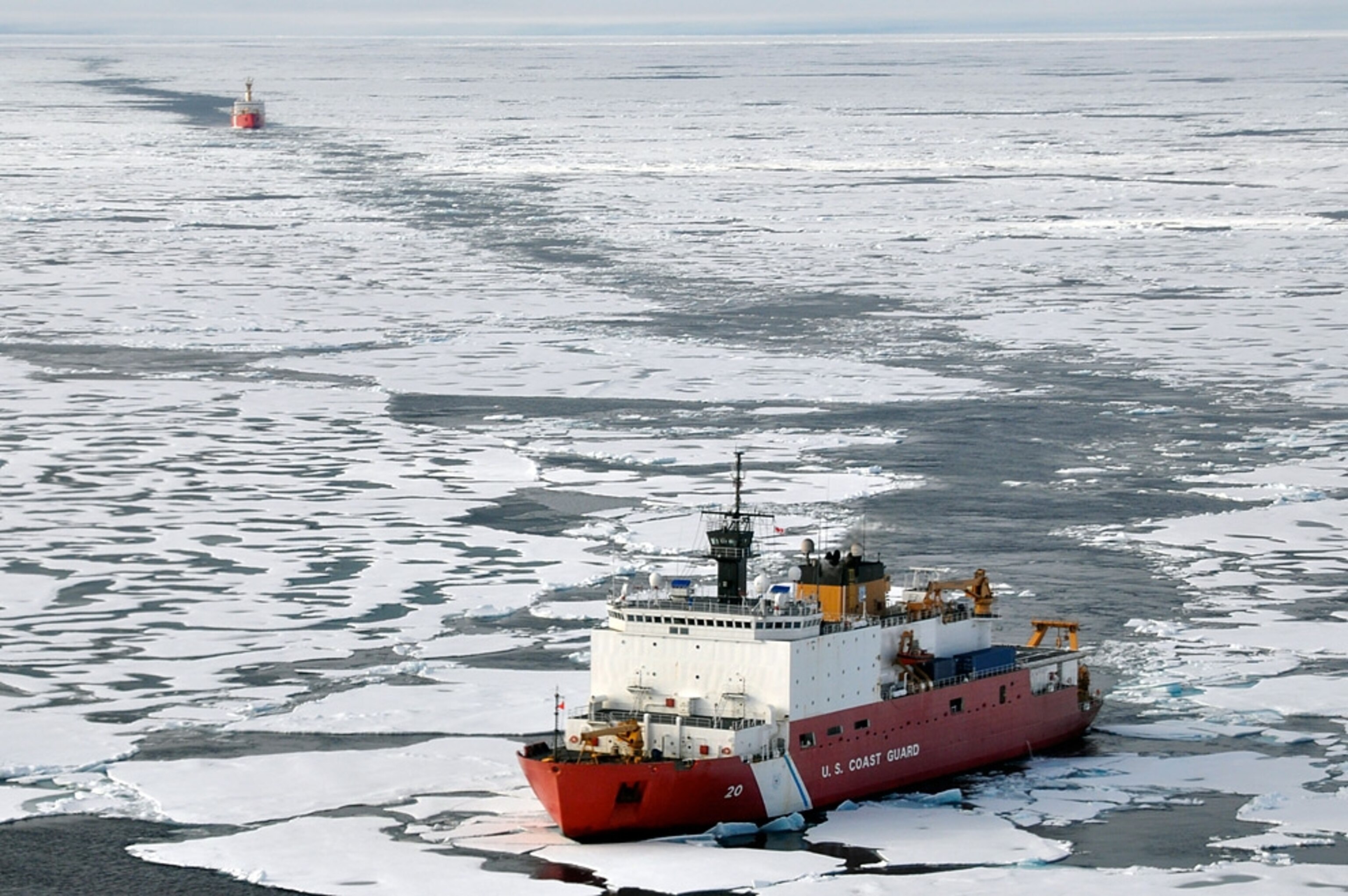 The U.S. Coast Guard Cutter Healy breaks ice ahead of the Canadian Coast Guard Ship Louis S. St-Laurent in the Arctic Ocean