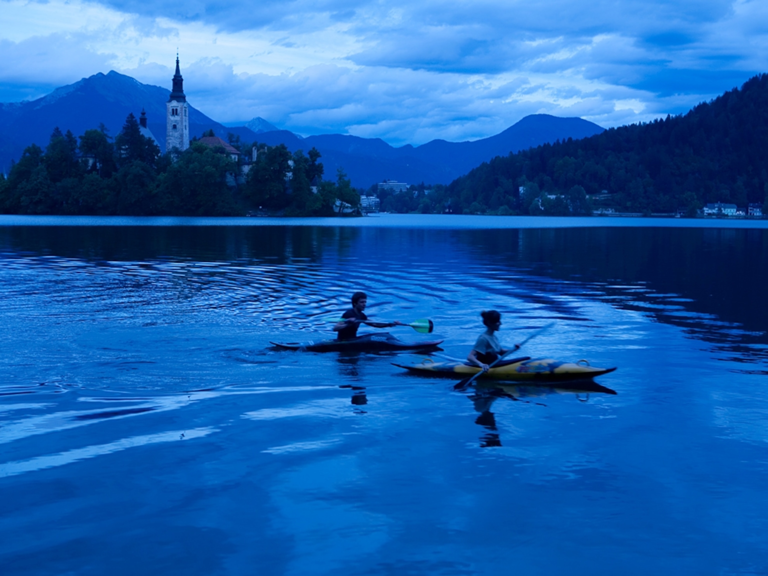 kayakers on Lake Bled at dusk, Slovenia