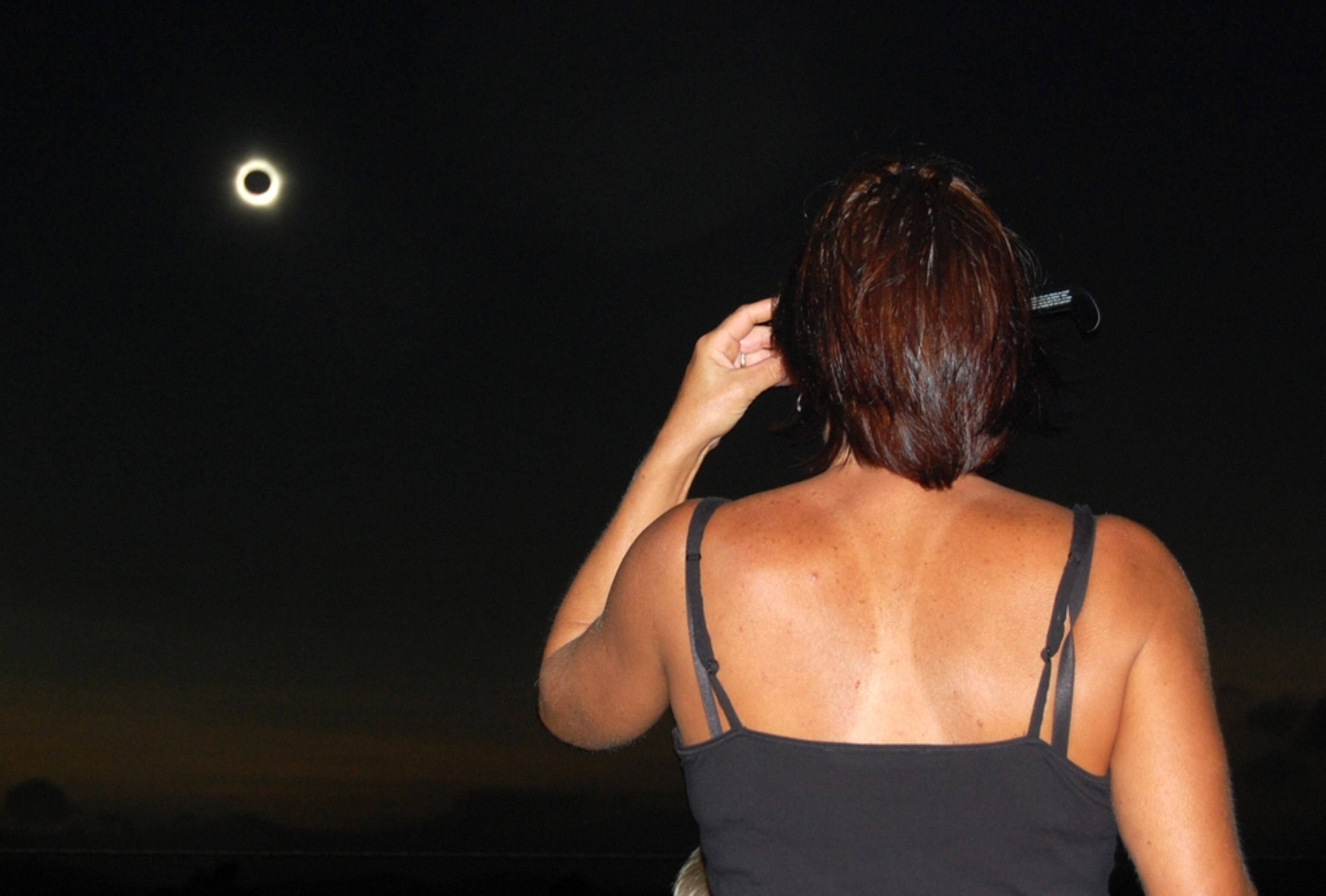 a woman watching a total solar eclipse