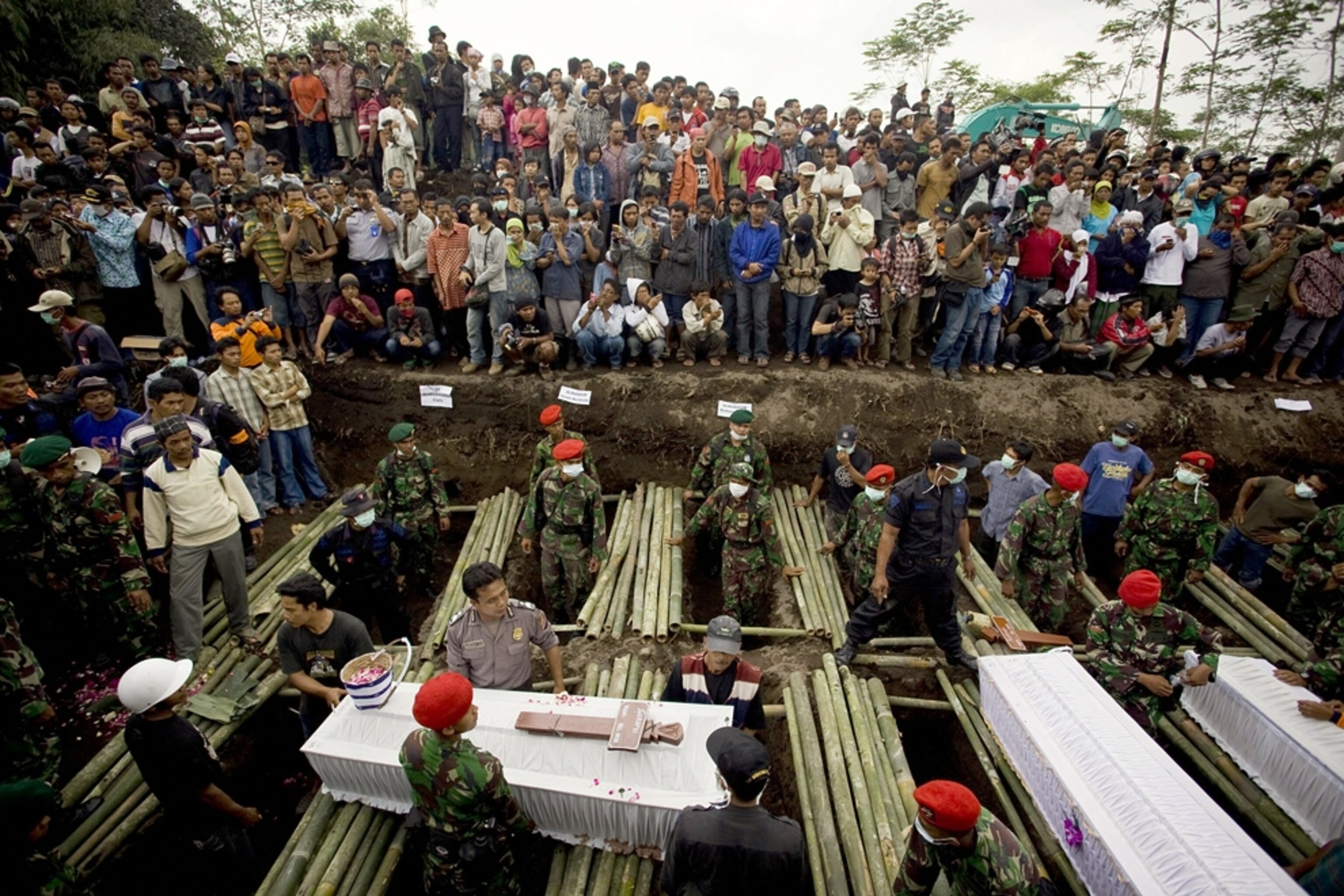 Coffins containing victims of the Indonesian Mount Merapi volcano eruption are interred during a mass burial in Sleman, Indonesia.