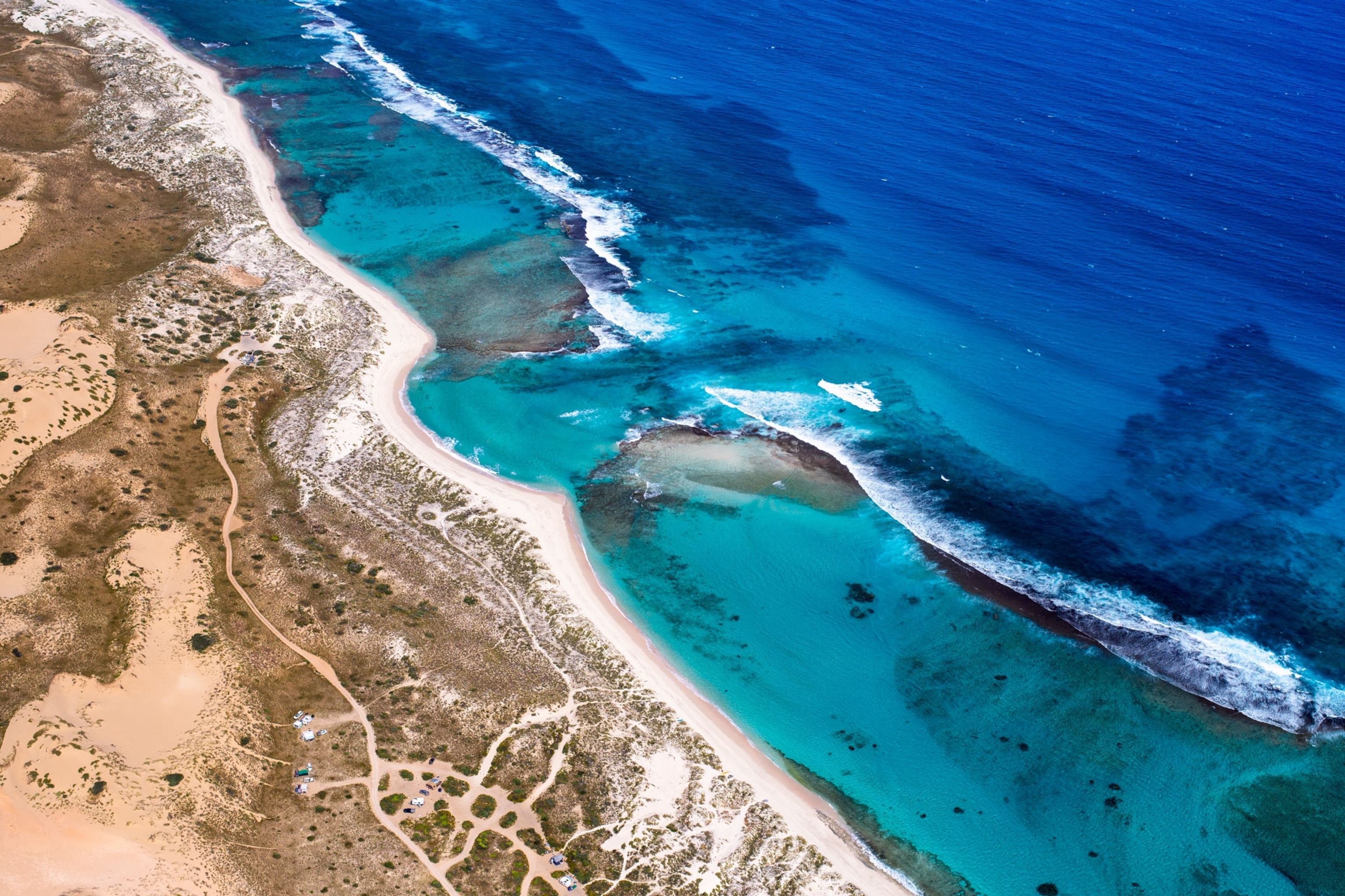 aerial view of a beach with deep blue water
