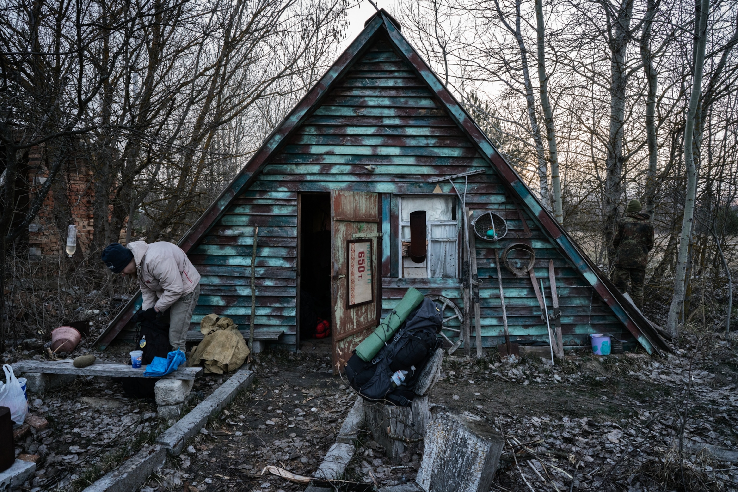 Aleksandr Sherekh in front of the foresters cabin while preparing his backpack before heading to Pripyat