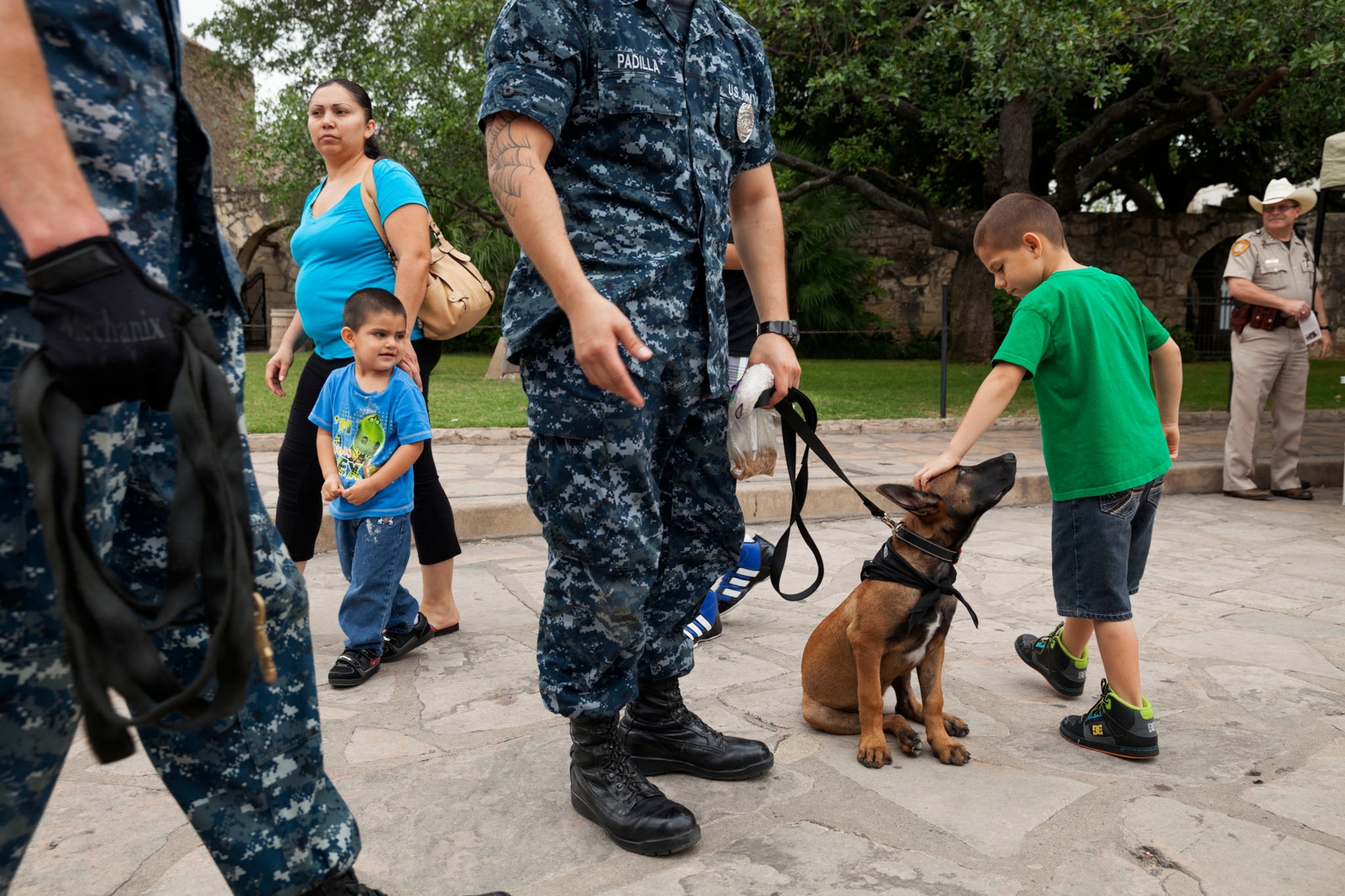 people from the public interacting with Quantico, a 14-week old Belgian Malinois