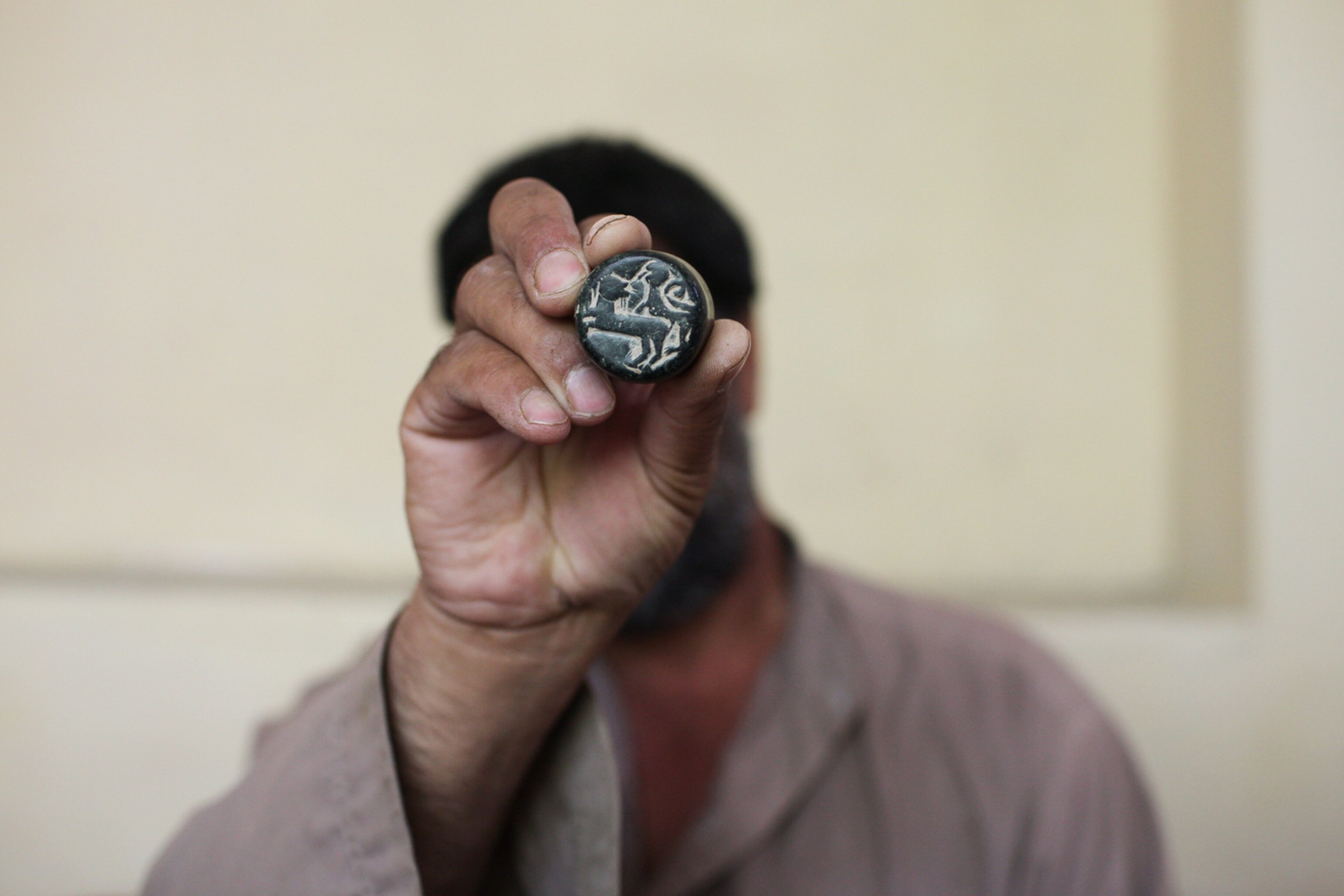 a man holding an antique stamp from Afghanistan