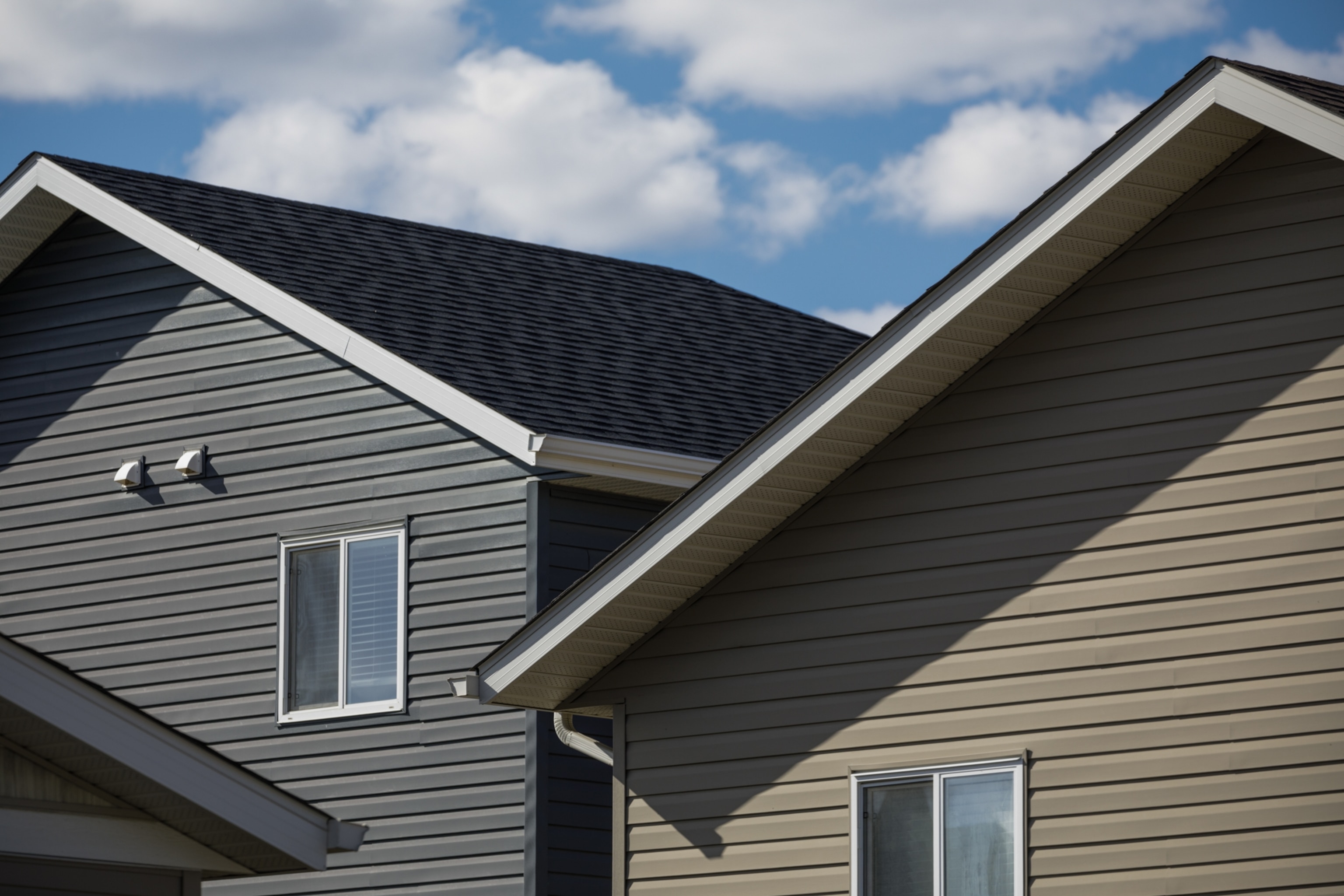 Two single family homes against a blue sky.