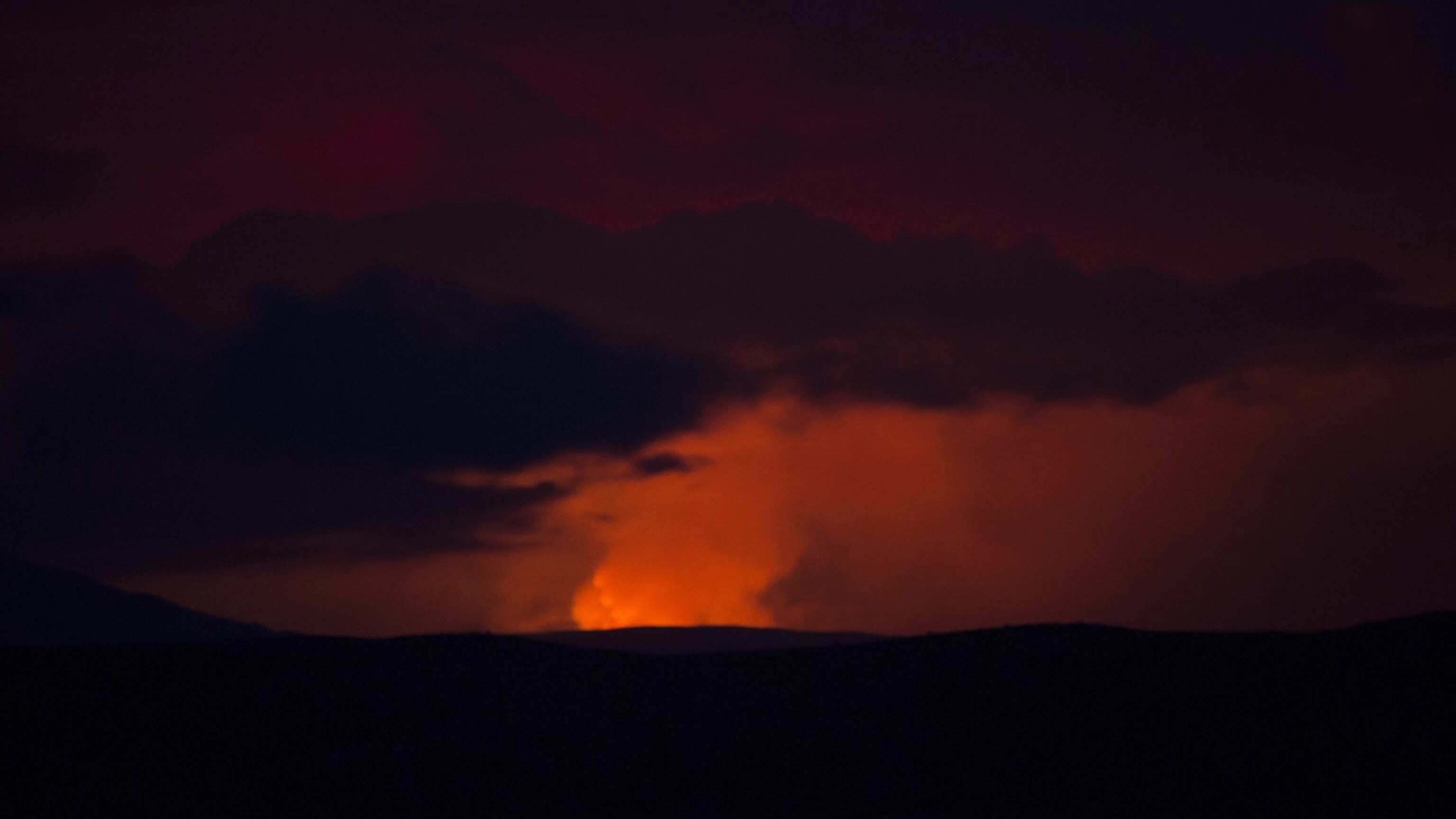 the night sky illuminated by the glow of the volcano