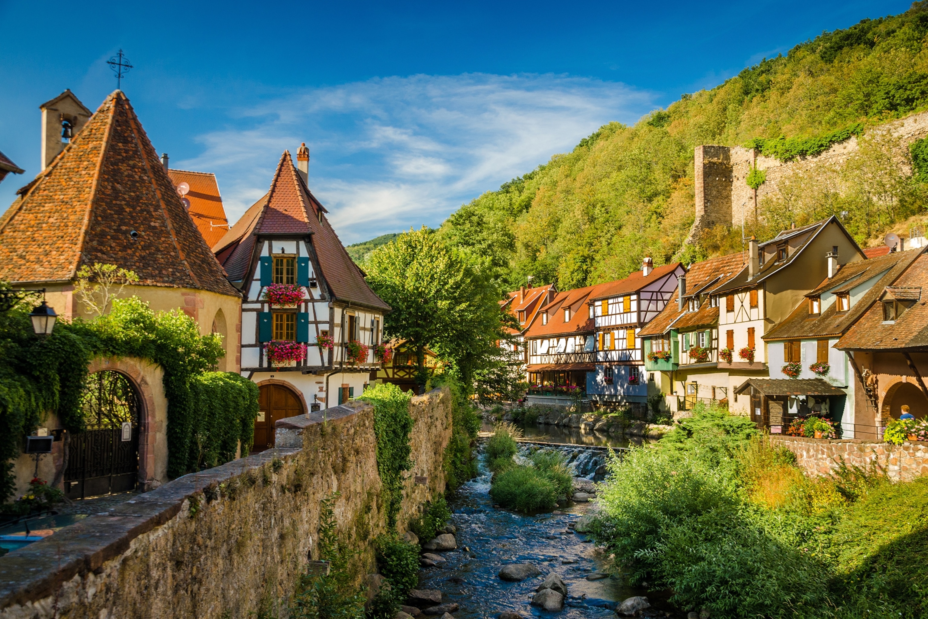 A quaint town of half-timbered houses with a rocky river running through the center.