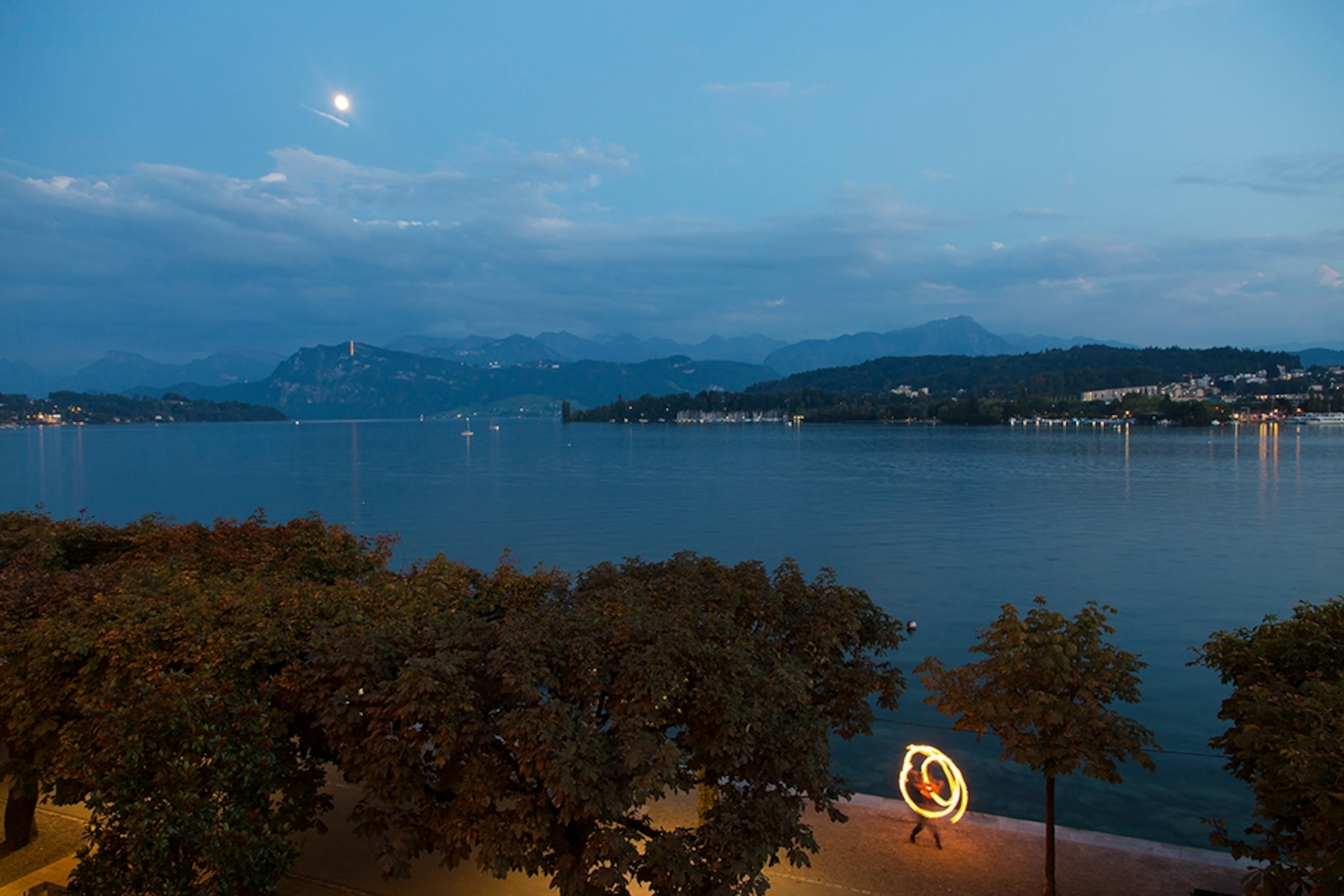 a fire performer on the shore of Lake Lucerne, Switzerland